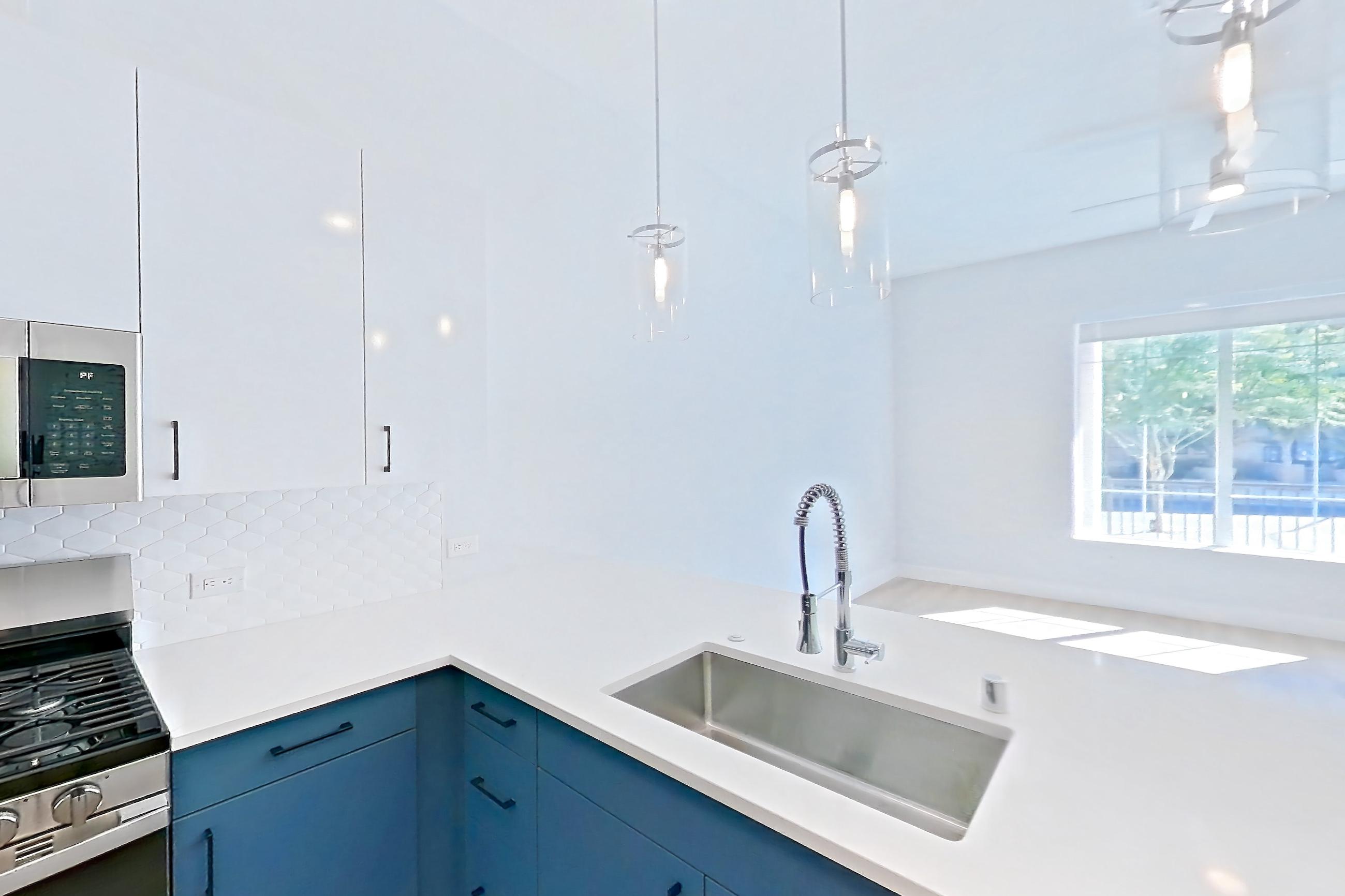 Kitchen with dishwasher, gas range, light countertops, light stone countertops, light wood-finish flooring, microwave, oven/range, refrigerator, stainless steel appliances, and water & ice dispenser, Apartment 130 at Bria