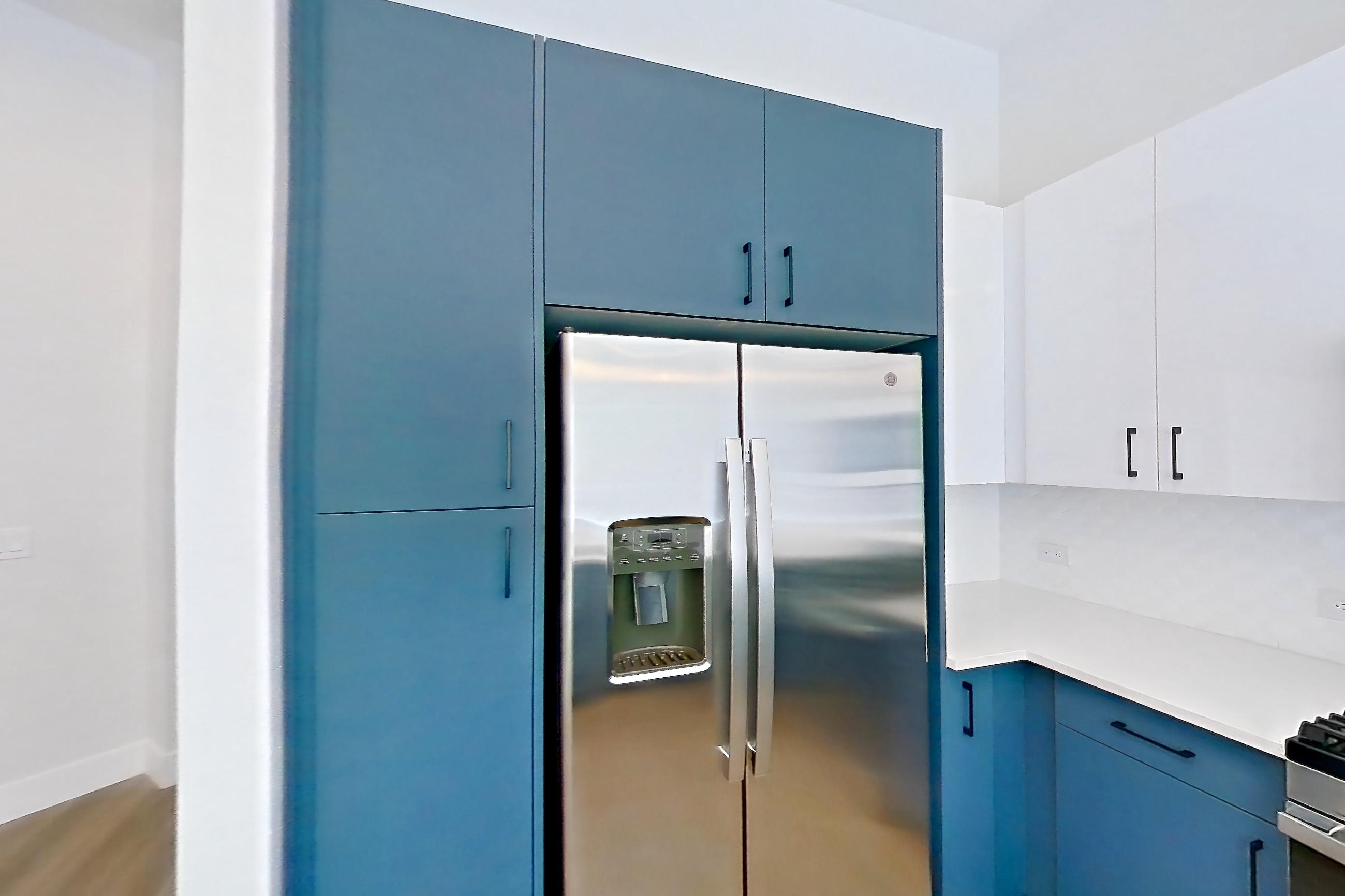 Kitchen with dishwasher, gas range, light countertops, light stone countertops, light wood-finish flooring, microwave, oven/range, refrigerator, stainless steel appliances, and water & ice dispenser, Apartment 130 at Bria