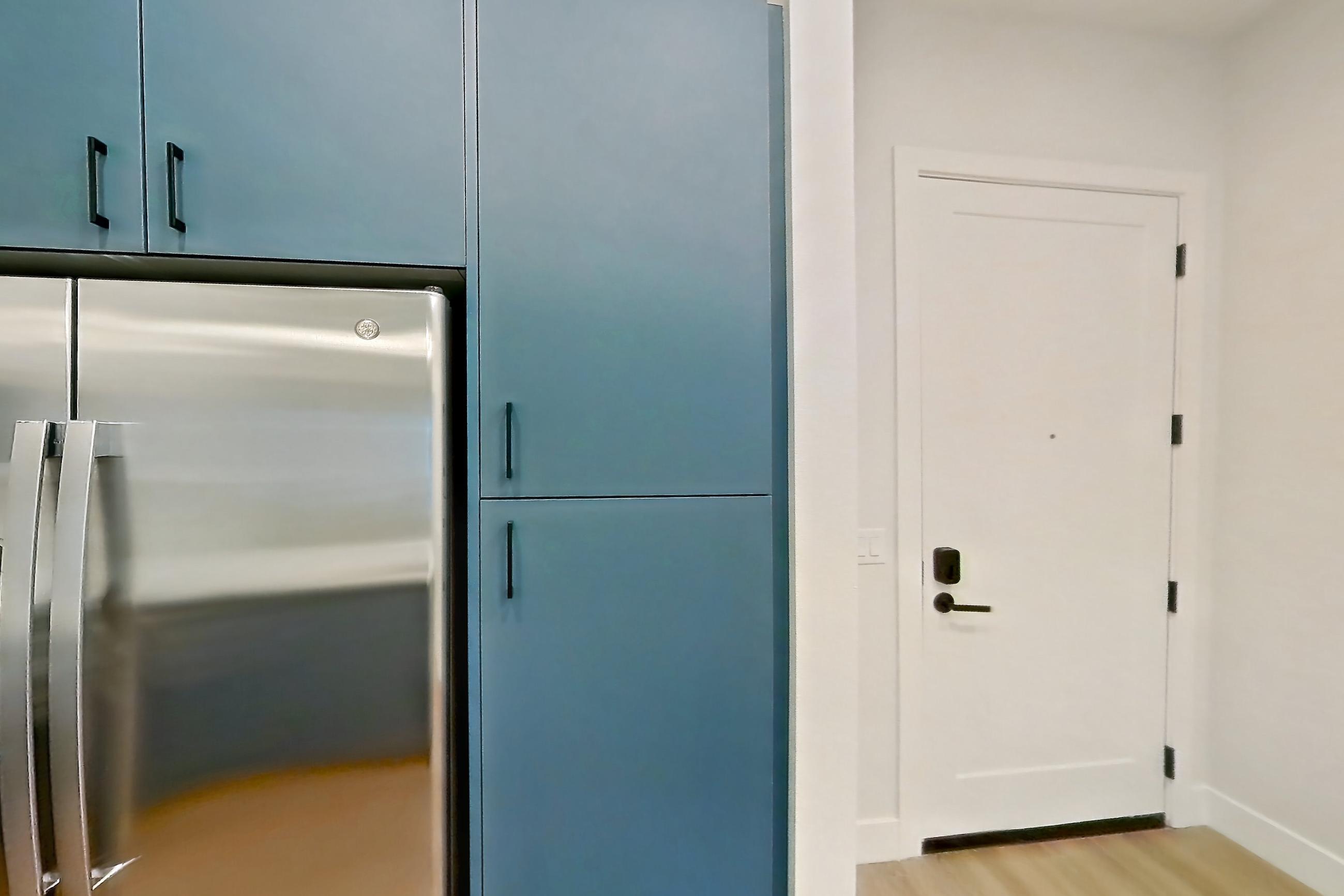 Kitchen with dishwasher, gas range, light countertops, light stone countertops, light wood-finish flooring, oven/range, refrigerator, stainless steel appliances, and water & ice dispenser, Apartment 111 at Bria