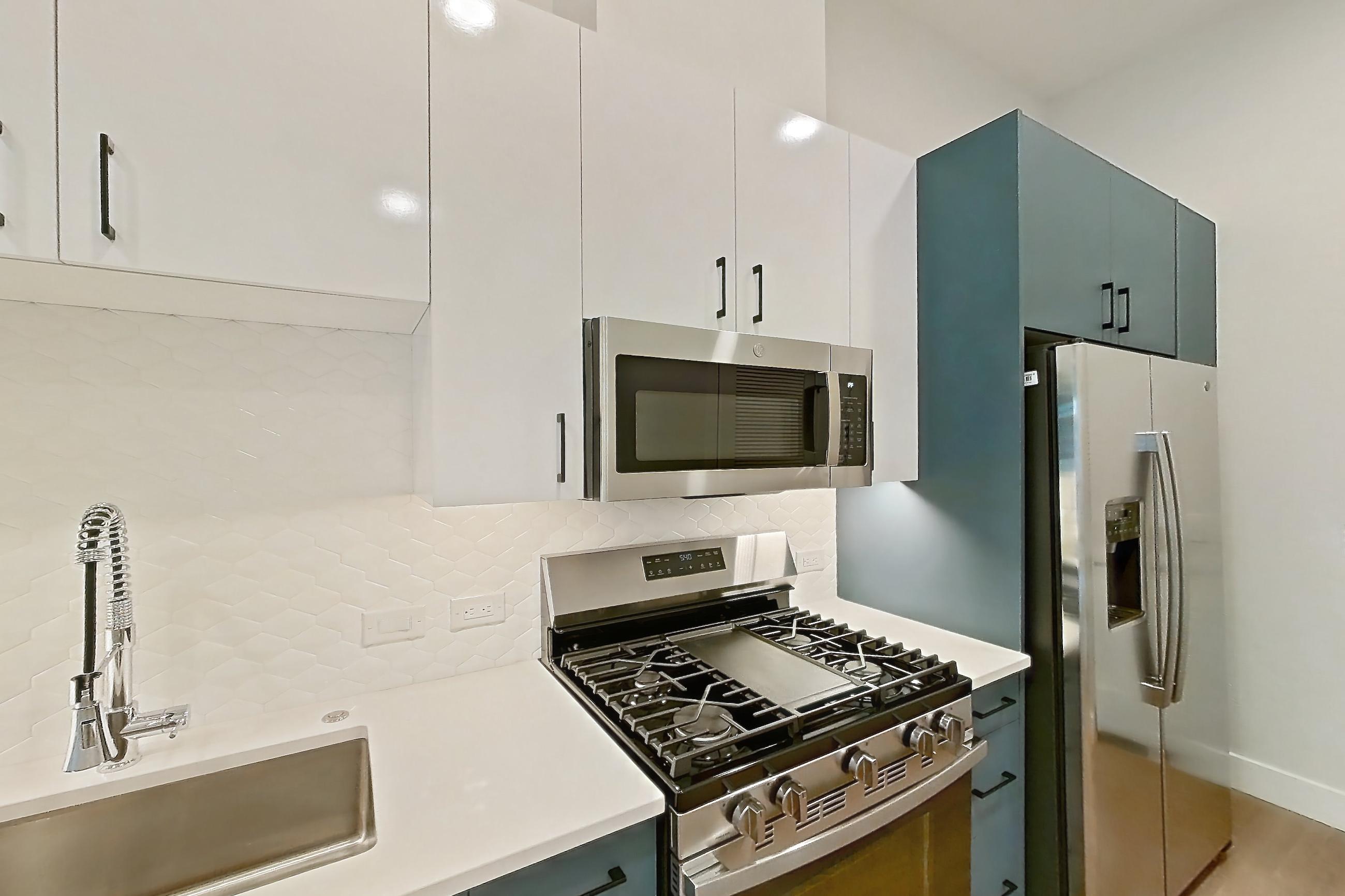 Kitchen with dishwasher, gas range, light countertops, light wood-finish flooring, microwave, oven/range, refrigerator, stainless steel appliances, and water & ice dispenser, Apartment 117 at Bria