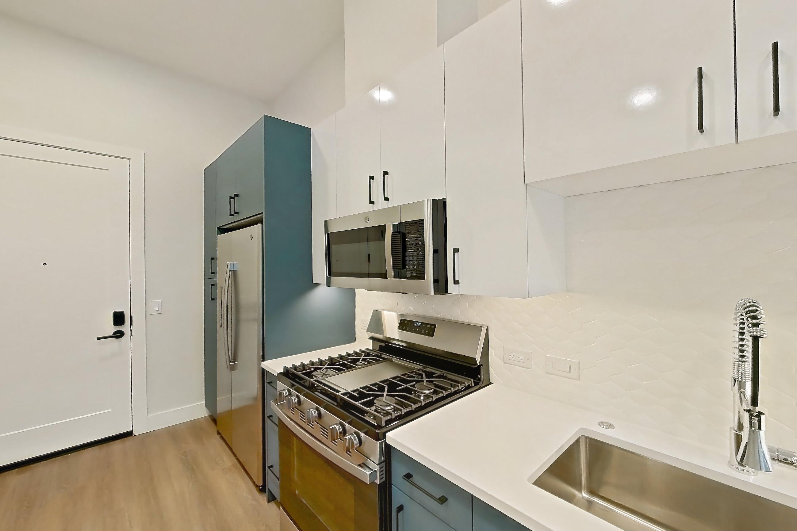 Kitchen with dishwasher, gas range, light countertops, light wood-finish flooring, microwave, oven/range, refrigerator, and stainless steel appliances, Apartment 121 at Bria