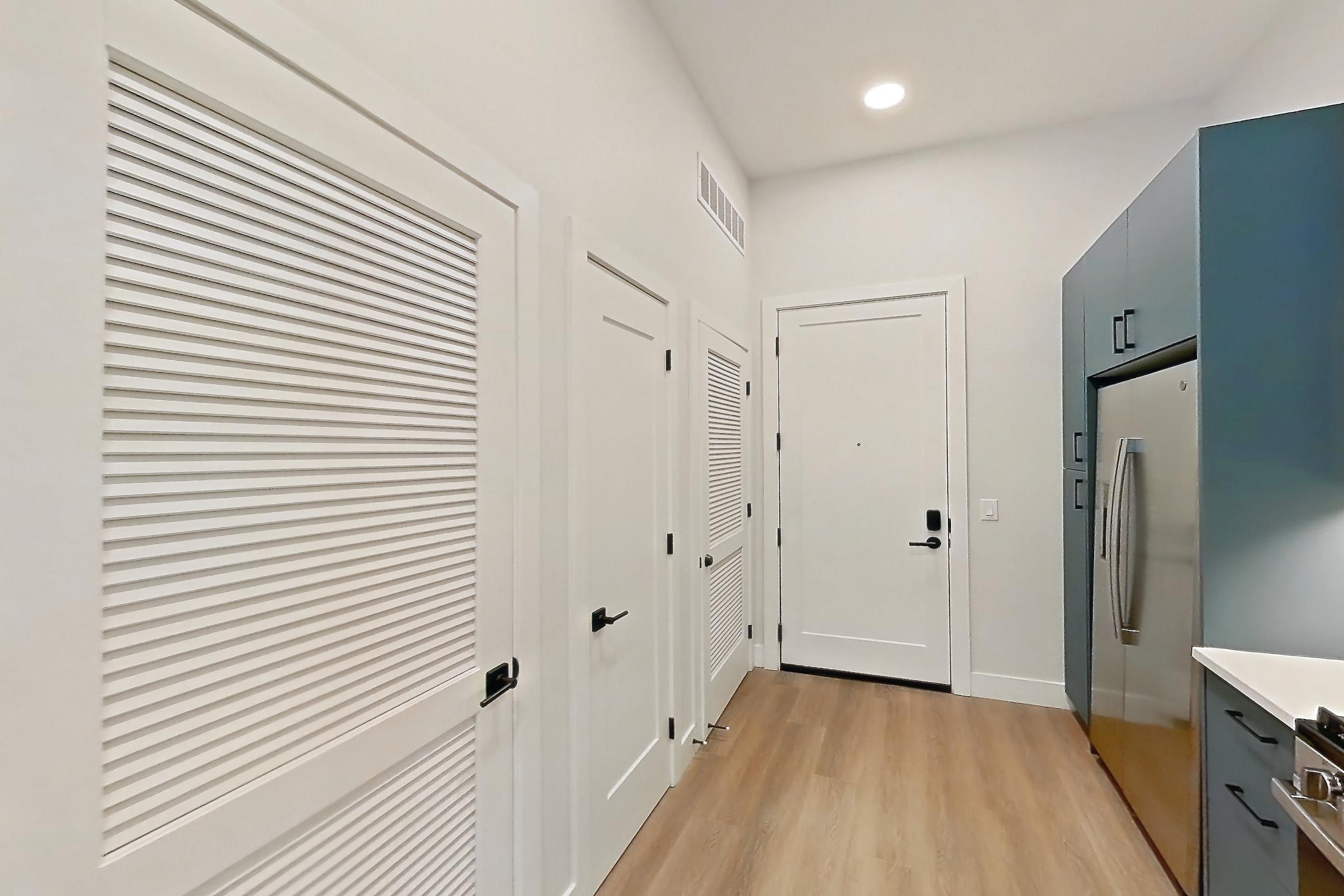 Kitchen with dishwasher, gas range, light countertops, light stone countertops, light wood-finish flooring, microwave, oven/range, and stainless steel appliances, Apartment 119 at Bria