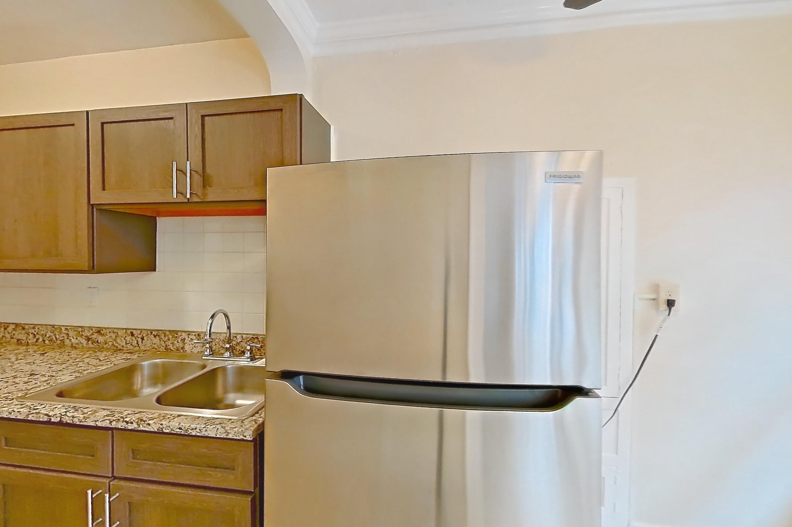 Kitchen with gas range, light countertops, light stone countertops, light wood-finish flooring, oven/range, refrigerator, and stainless steel appliances, Apartment MVI-11 at Mapleview
