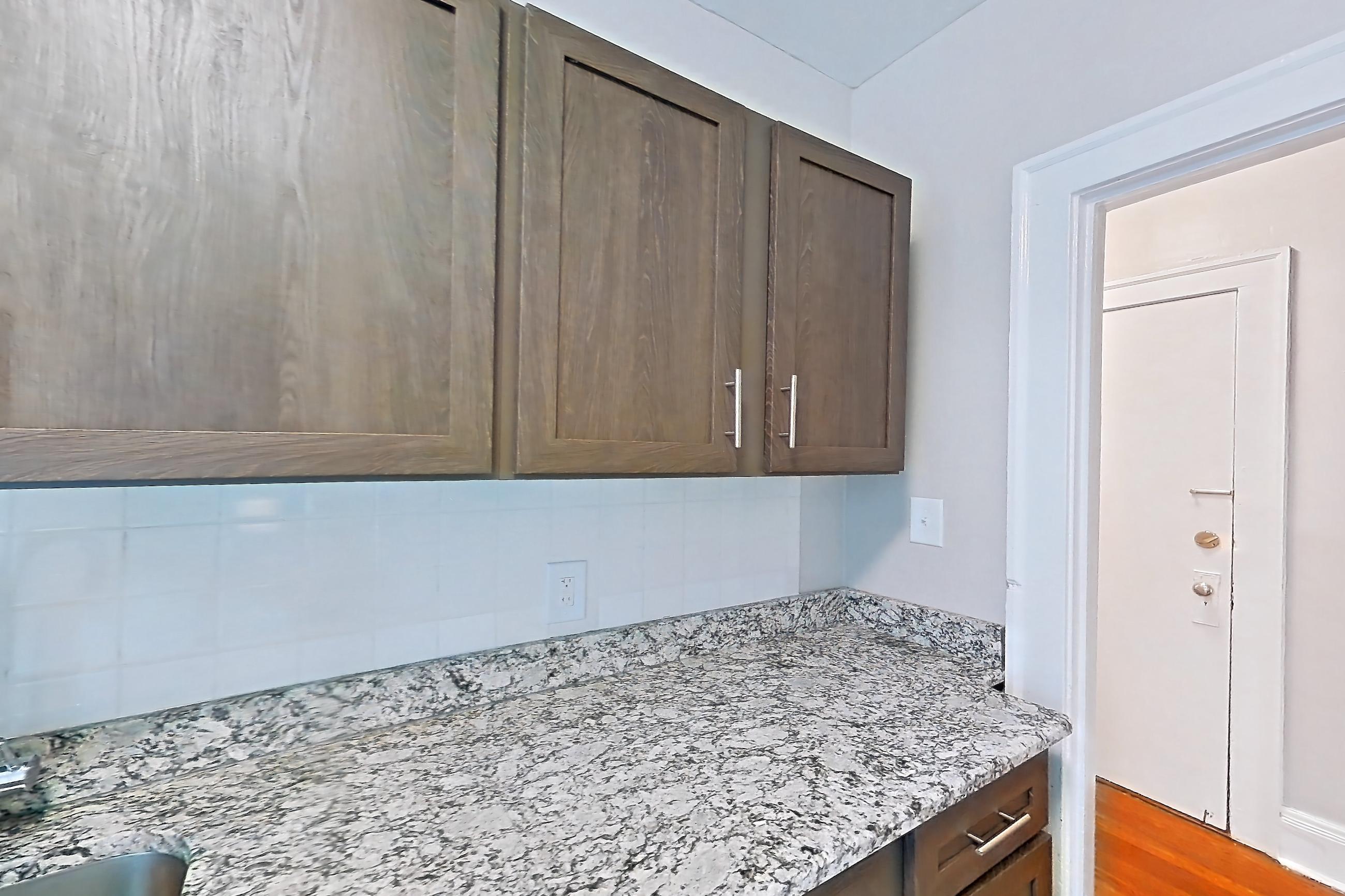 Kitchen with gas range, light stone countertops, light wood-finish flooring, oven/range, refrigerator, and stainless steel appliances, Apartment MVI-10 at Mapleview