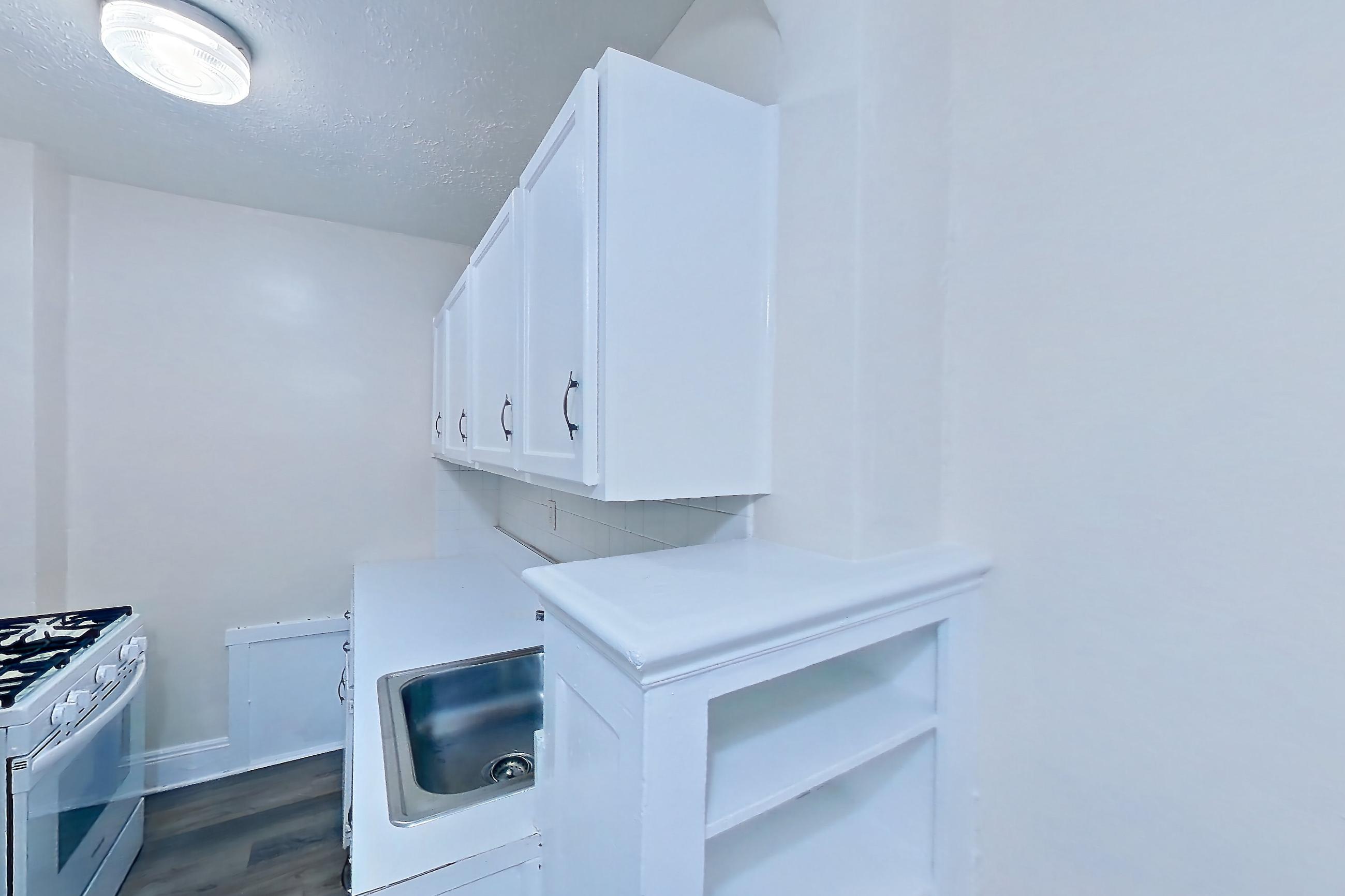 Kitchen with gas range, light countertops, light wood-finish flooring, oven/range, refrigerator, and white appliances, Apartment MVI-03 at Mapleview