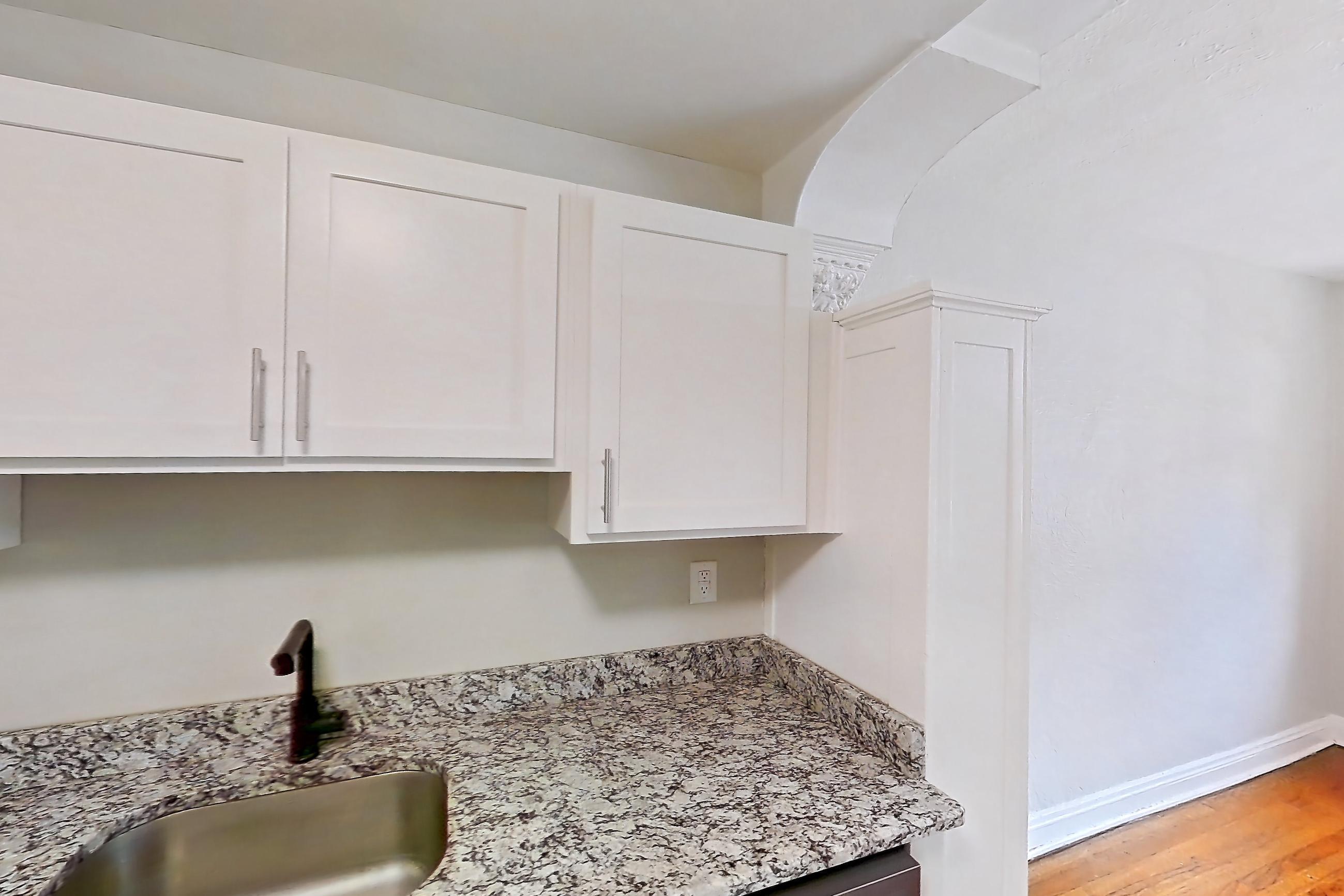 Kitchen with dishwasher, gas range, light countertops, light stone countertops, light tile flooring, oven/range, refrigerator, and stainless steel appliances, Apartment 89-108 at Lewis Manor