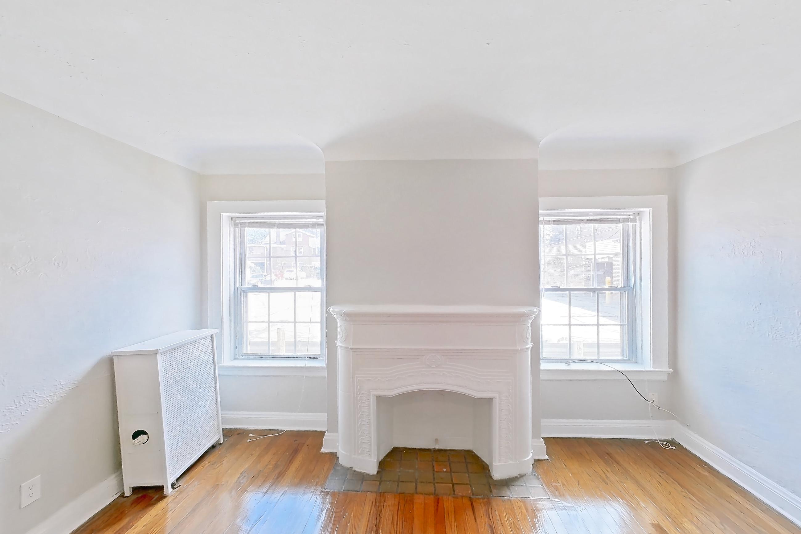 Living room with fireplace, light wood-finish flooring, and wood-finish flooring, Apartment 89-108 at Lewis Manor