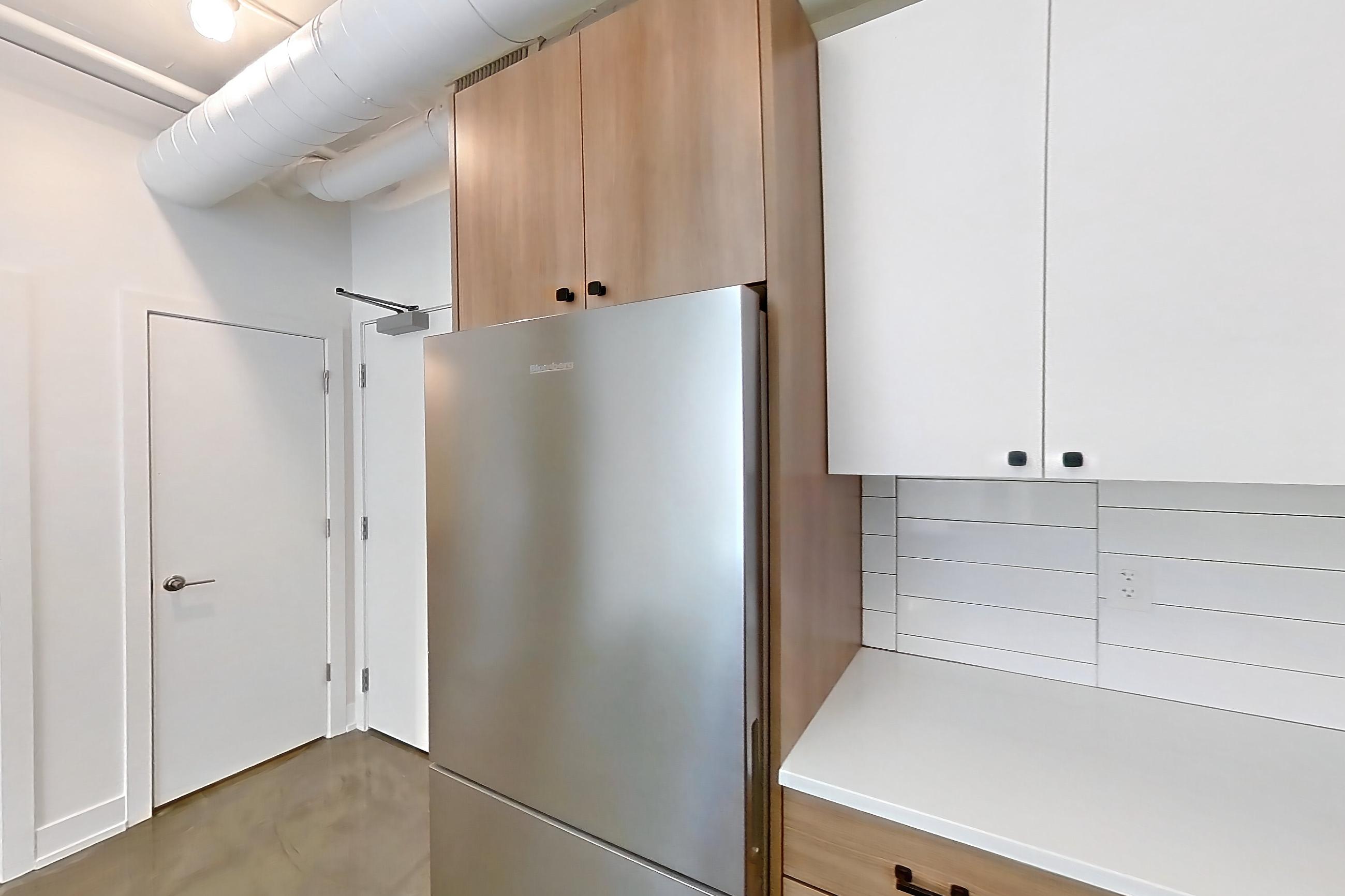 Kitchen with dark concrete flooring, dishwasher, gas range, light countertops, oven/range, refrigerator, and stainless steel appliances, Apartment 246 at The Hall Lofts