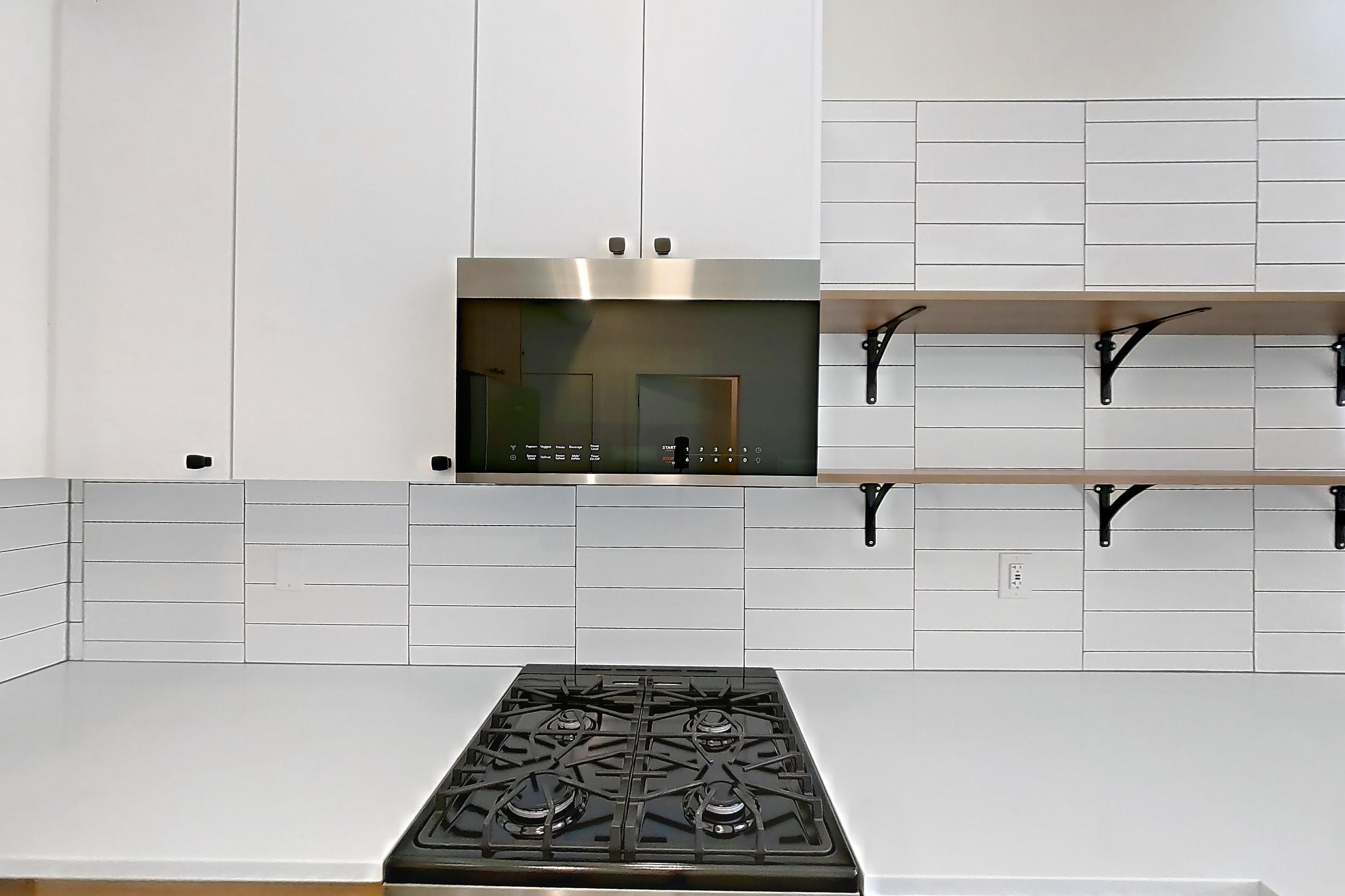 Kitchen with dark concrete flooring, dishwasher, gas range, light countertops, oven/range, refrigerator, and stainless steel appliances, Apartment 246 at The Hall Lofts