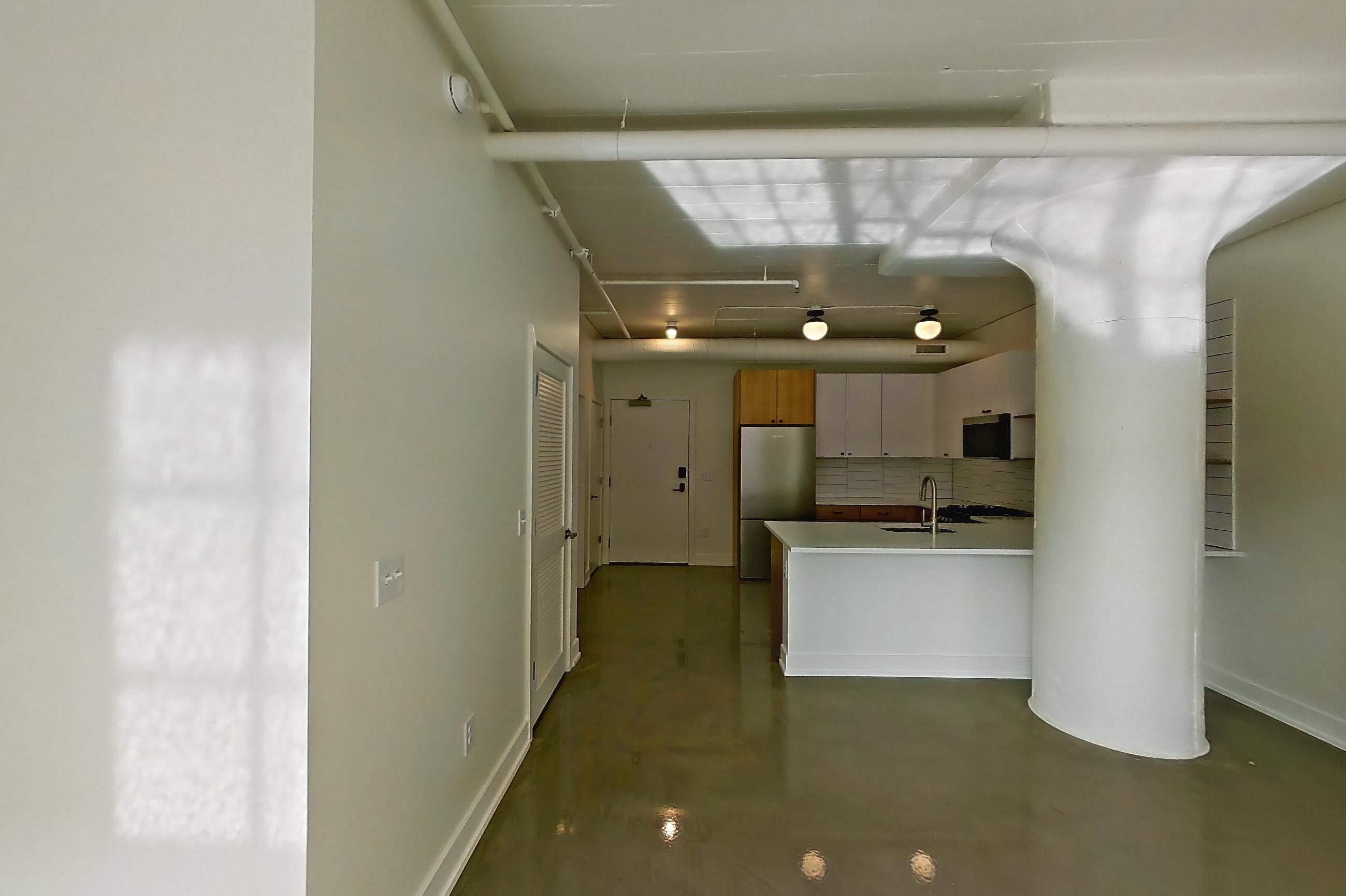 Living space with mini-split AC, refrigerator, and stainless steel appliances, Apartment 246 at The Hall Lofts