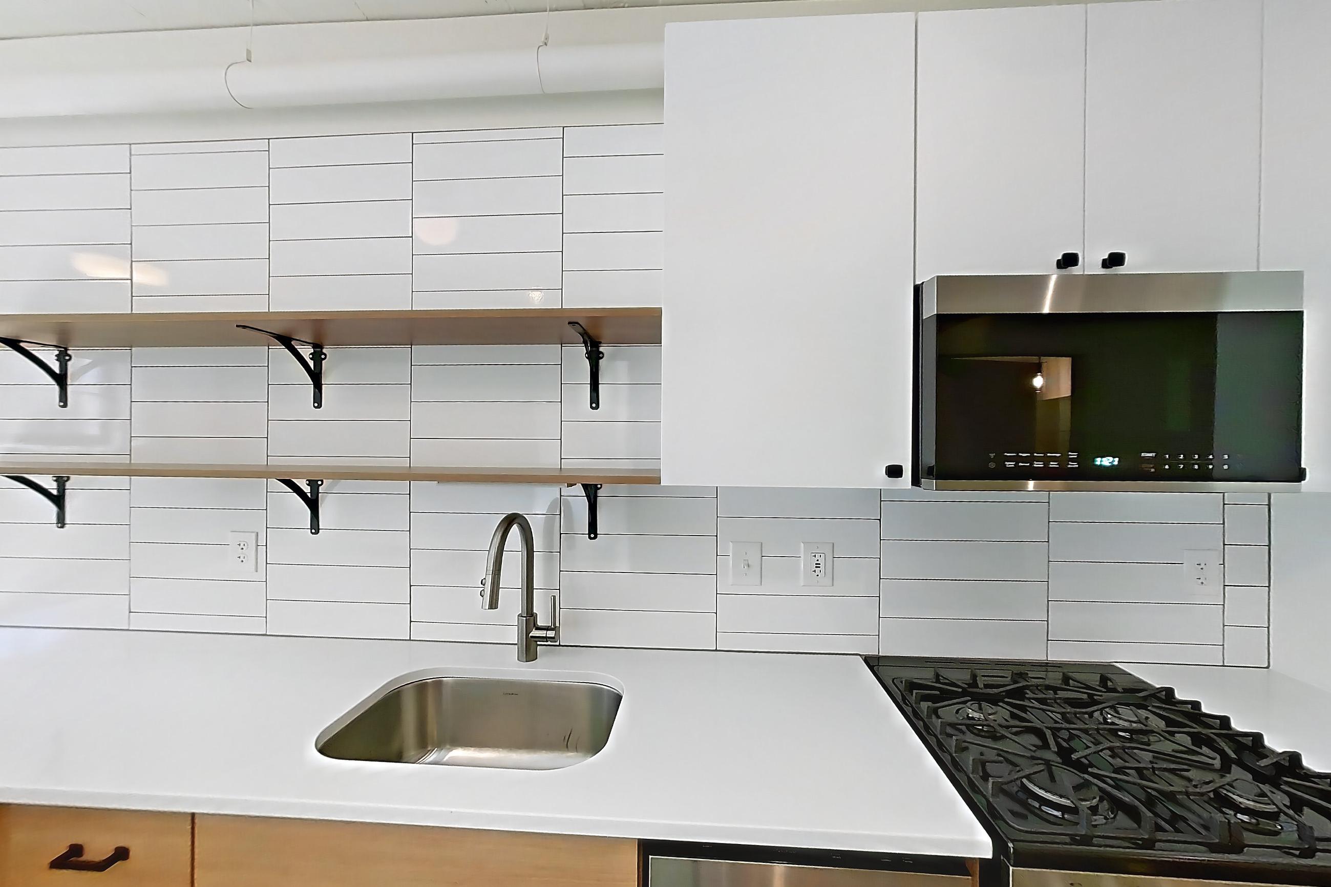 Kitchen with dishwasher, gas range, light countertops, oven/range, and stainless steel appliances, Apartment 444 at The Hall Lofts