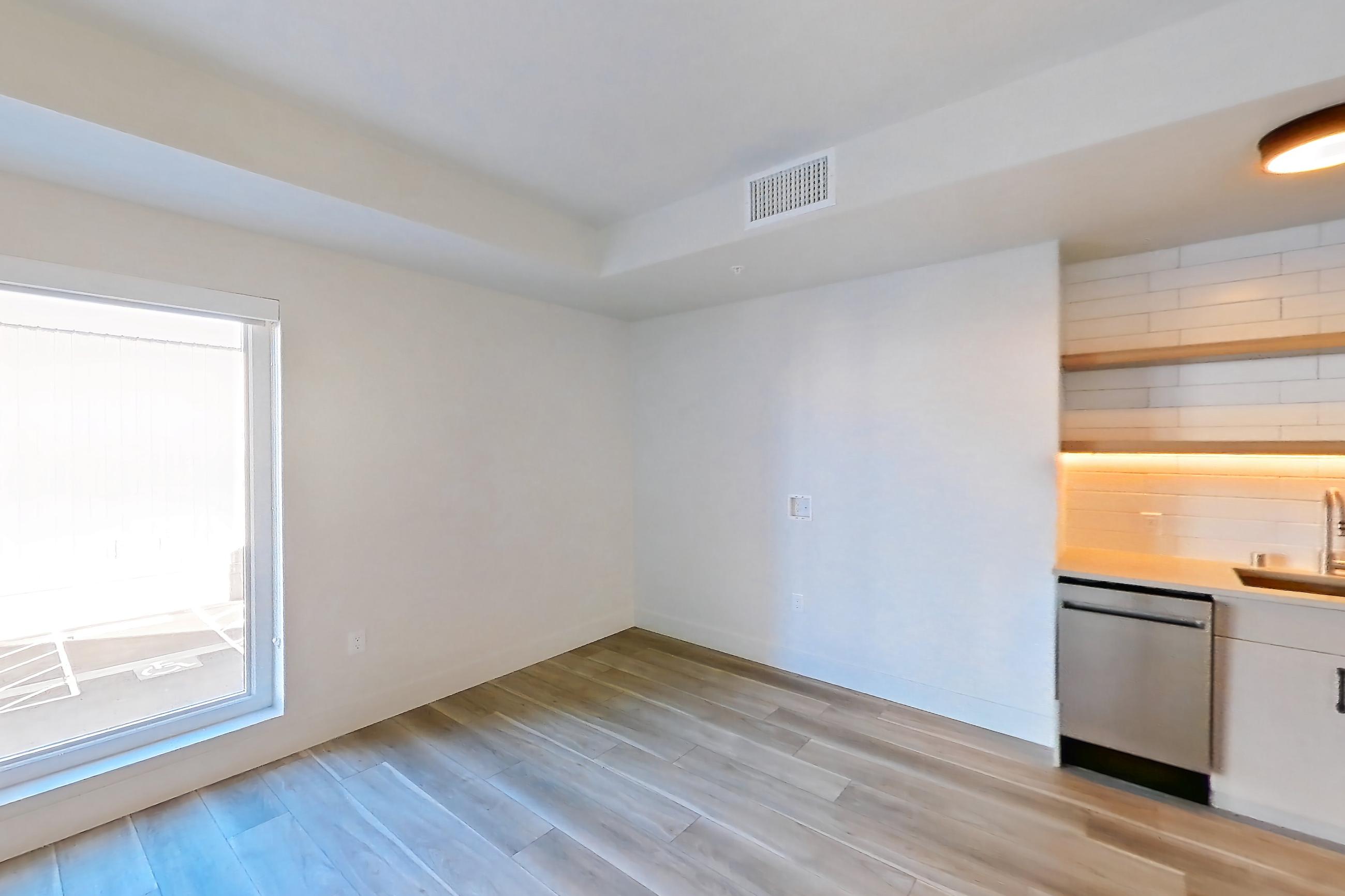 Living space with dishwasher, gas range, light countertops, light wood-finish flooring, oven/range, and stainless steel appliances, Apartment 220 at The Myles