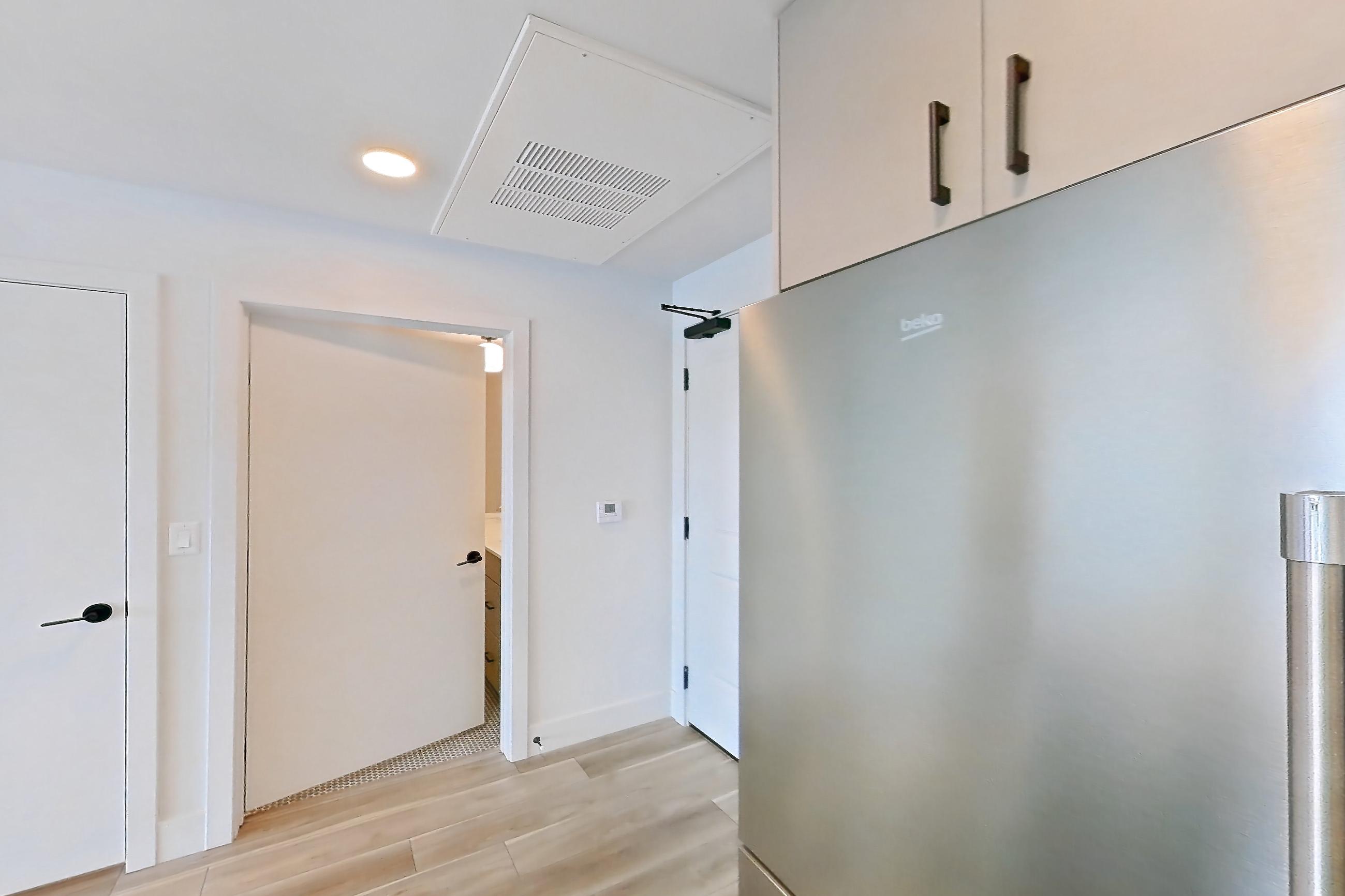 Kitchen with dishwasher, gas range, light countertops, light wood-finish flooring, microwave, oven/range, refrigerator, and stainless steel appliances, Apartment 230 at The Myles