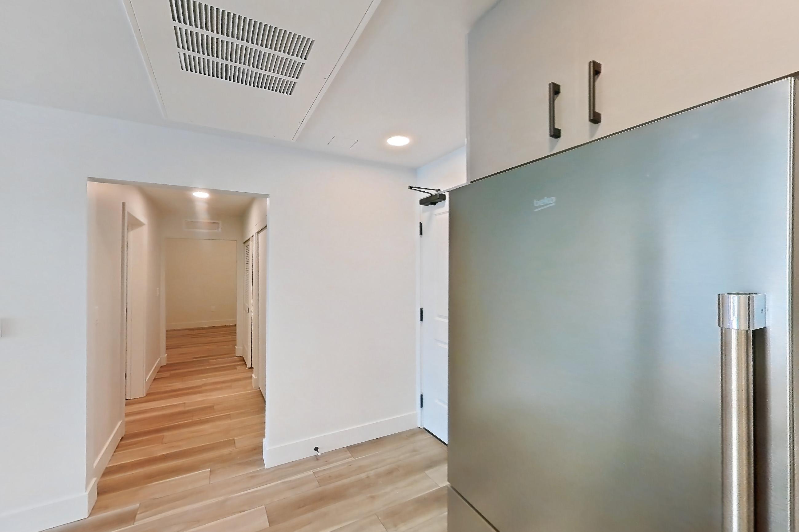 Kitchen with dishwasher, gas range, light countertops, light wood-finish flooring, microwave, oven/range, refrigerator, and stainless steel appliances, Apartment 311 at The Myles