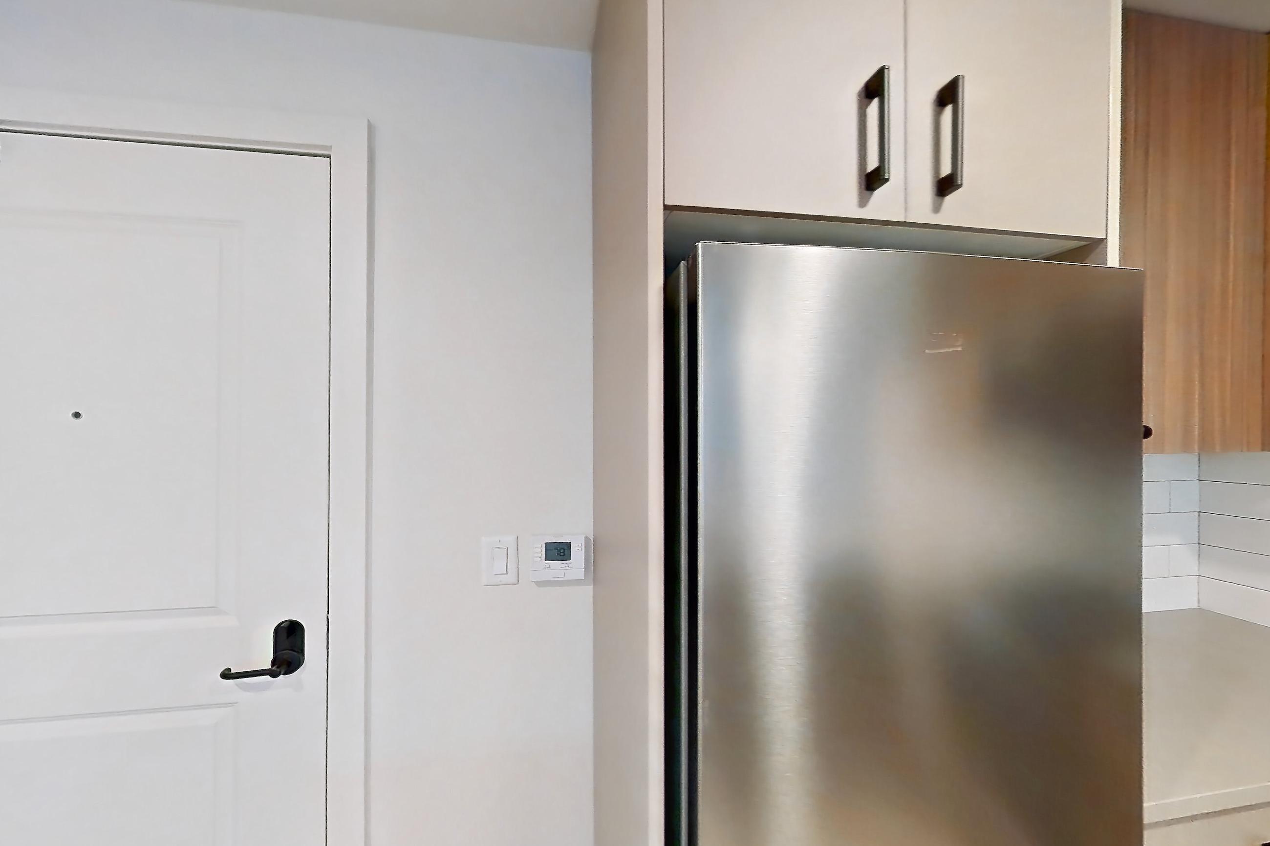 Kitchen with gas range, light countertops, light wood-finish flooring, oven/range, refrigerator, and stainless steel appliances, Apartment 319 at The Myles