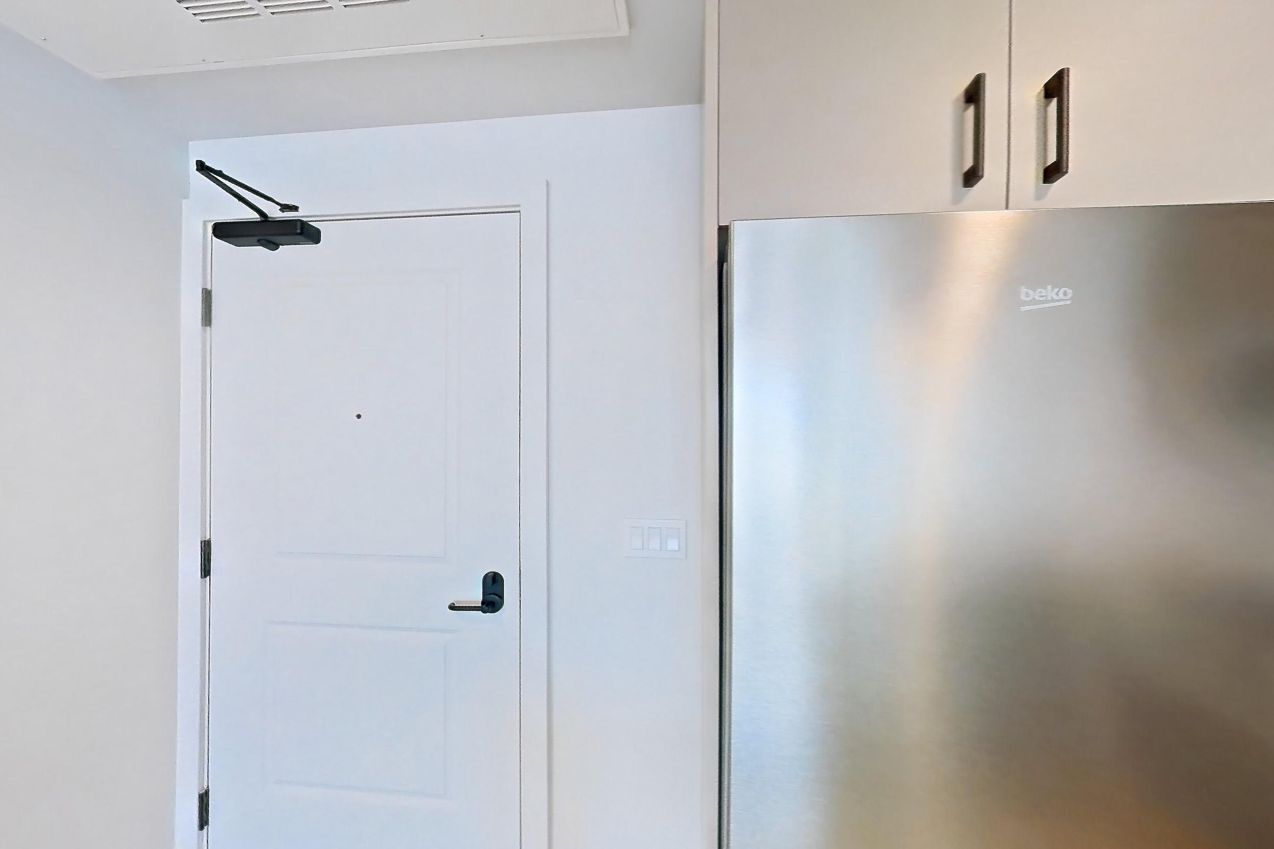 Kitchen with dishwasher, gas range, light countertops, light stone countertops, light wood-finish flooring, microwave, oven/range, refrigerator, and stainless steel appliances, Apartment 325 at The Myles
