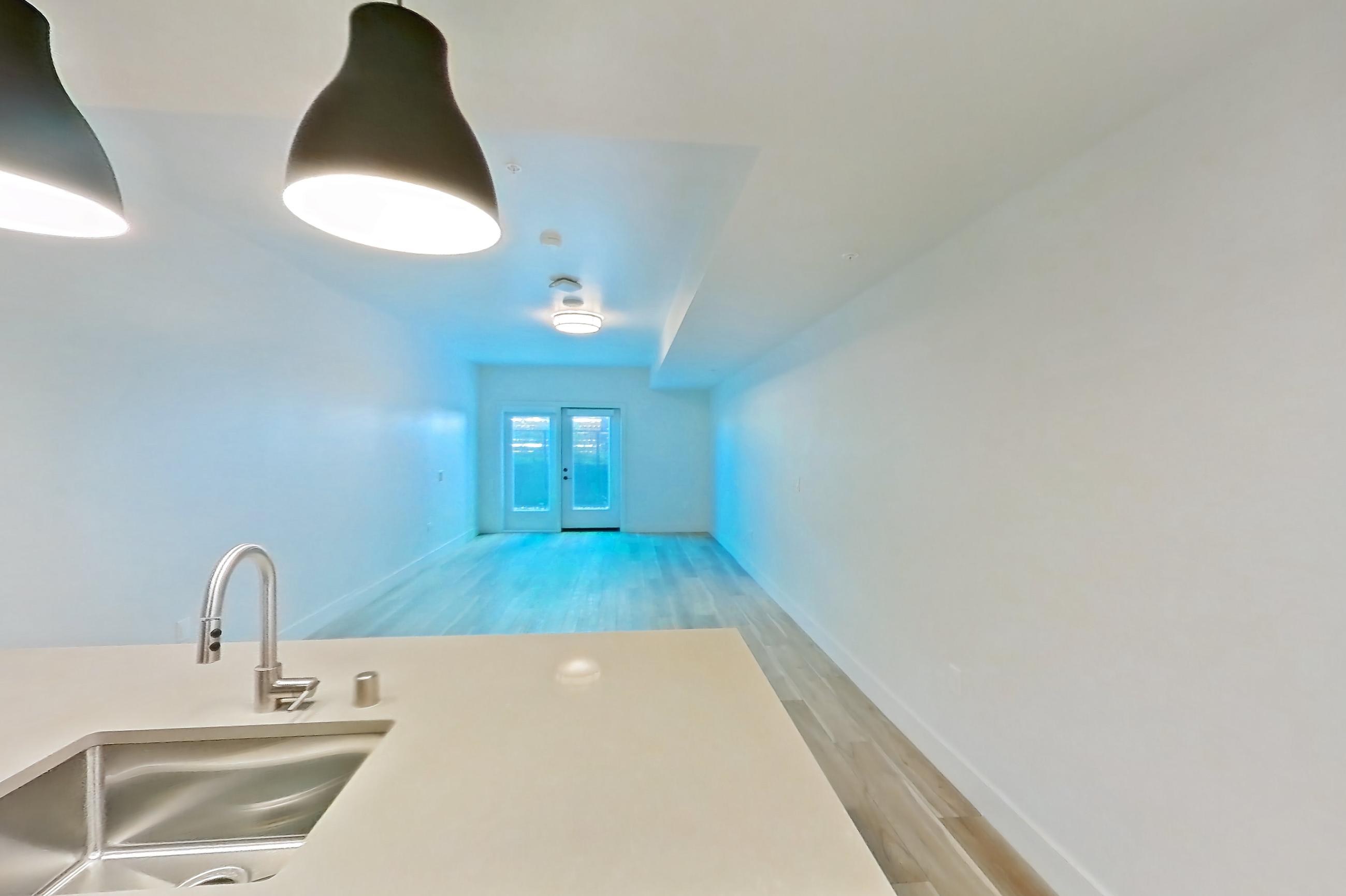 Kitchen with dishwasher, gas range, light countertops, light wood-finish flooring, microwave, oven/range, refrigerator, and stainless steel appliances, Apartment 327 at The Myles