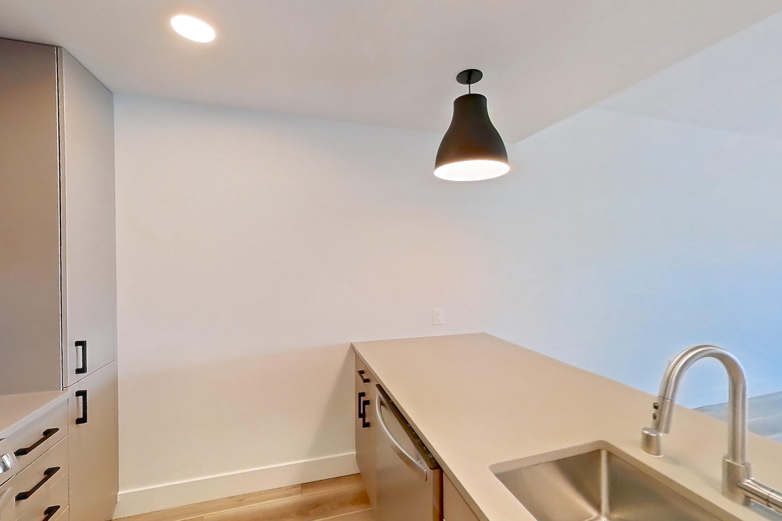 Kitchen with dishwasher, gas range, light countertops, light wood-finish flooring, microwave, oven/range, refrigerator, and stainless steel appliances, Apartment 330 at The Myles