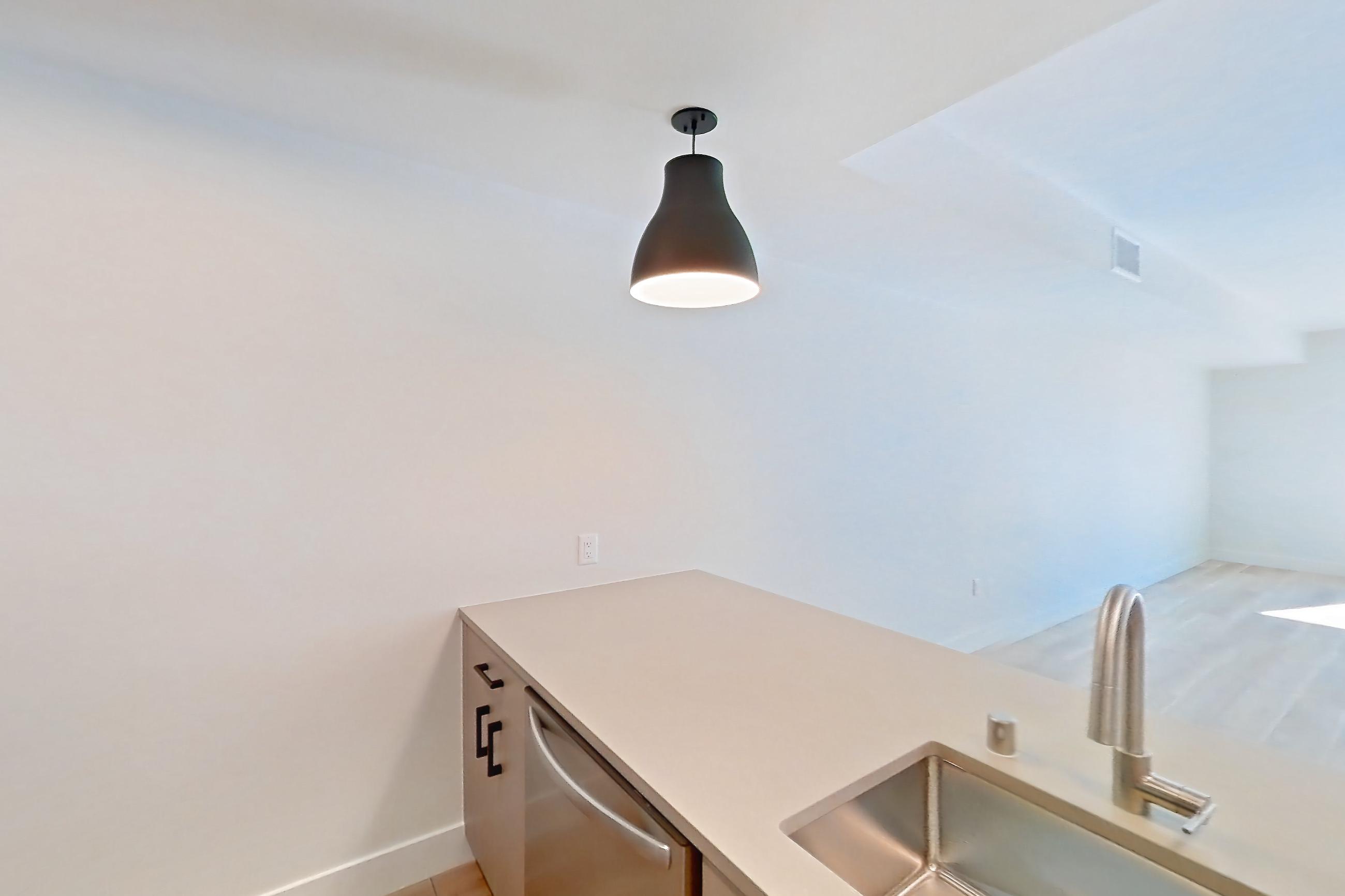 Kitchen with dishwasher, gas range, light countertops, light wood-finish flooring, oven/range, refrigerator, and stainless steel appliances, Apartment 403 at The Myles