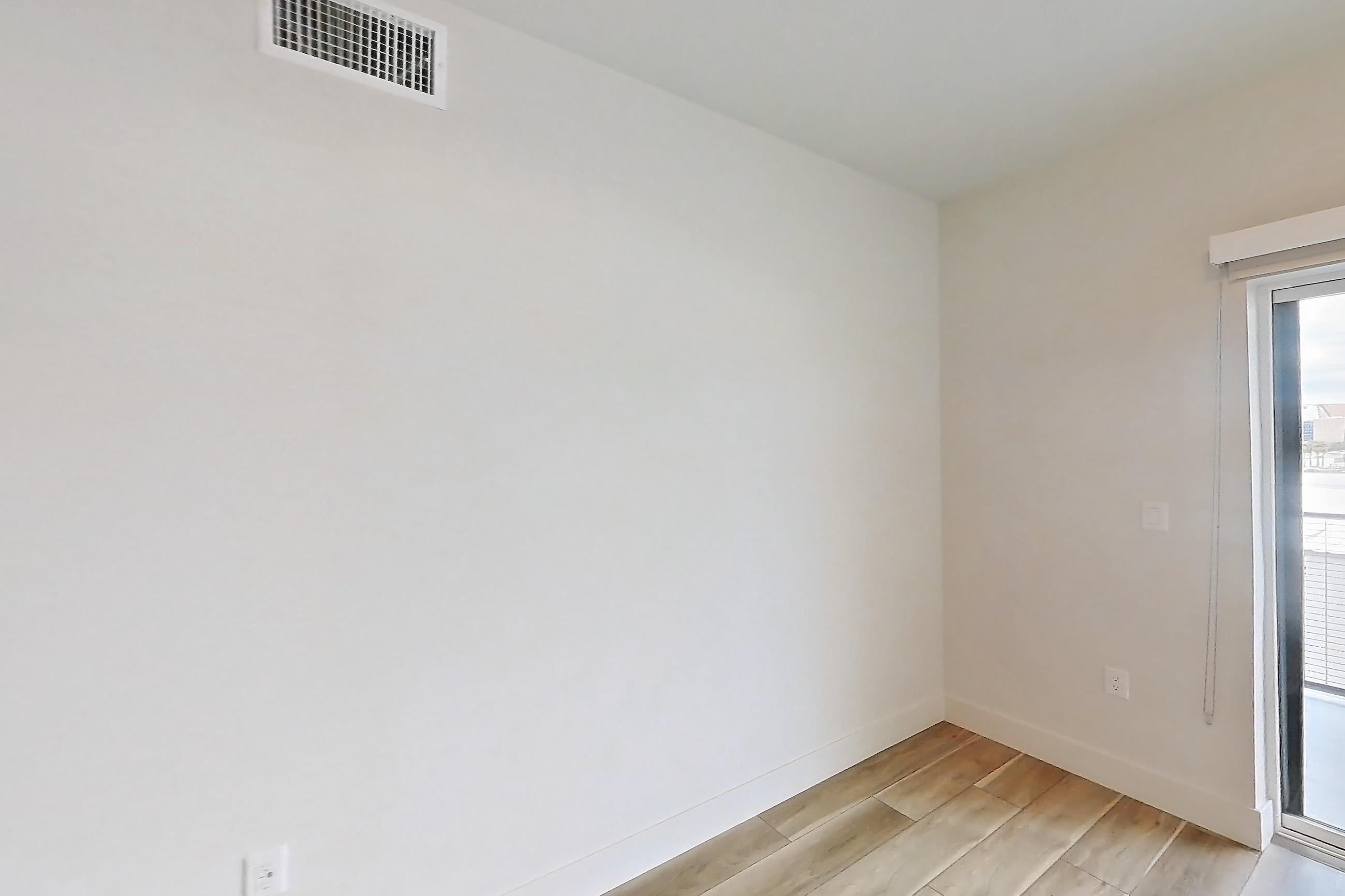 Living room with light wood-finish flooring, Apartment 434 at The Myles