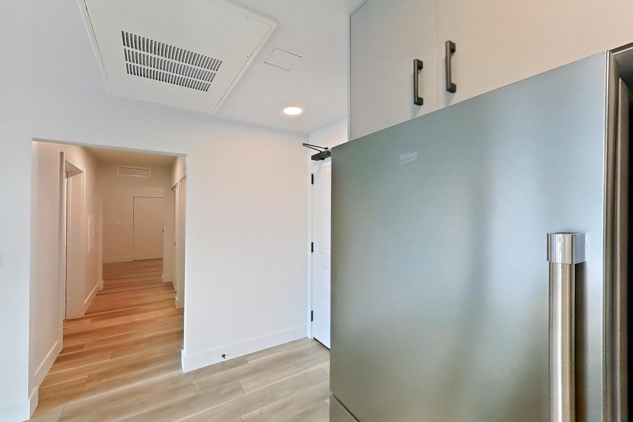 Kitchen with dishwasher, gas range, light countertops, light wood-finish flooring, microwave, oven/range, refrigerator, and stainless steel appliances, Apartment 446 at The Myles