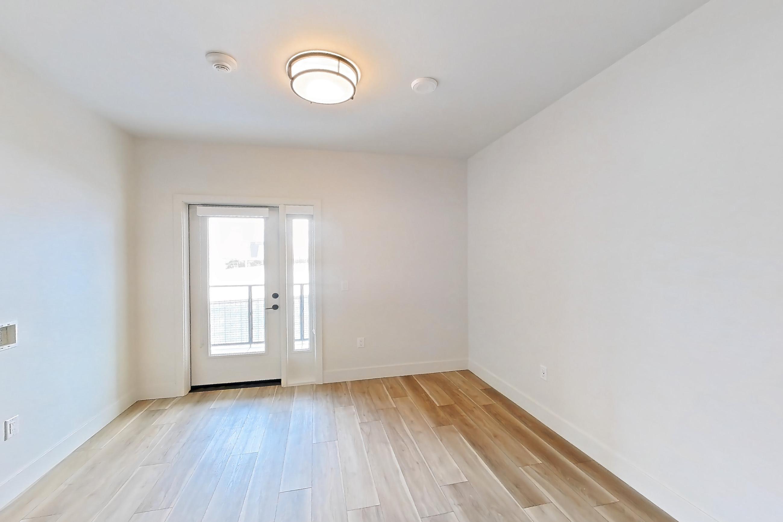 Living room with light wood-finish flooring, Apartment 447 at The Myles
