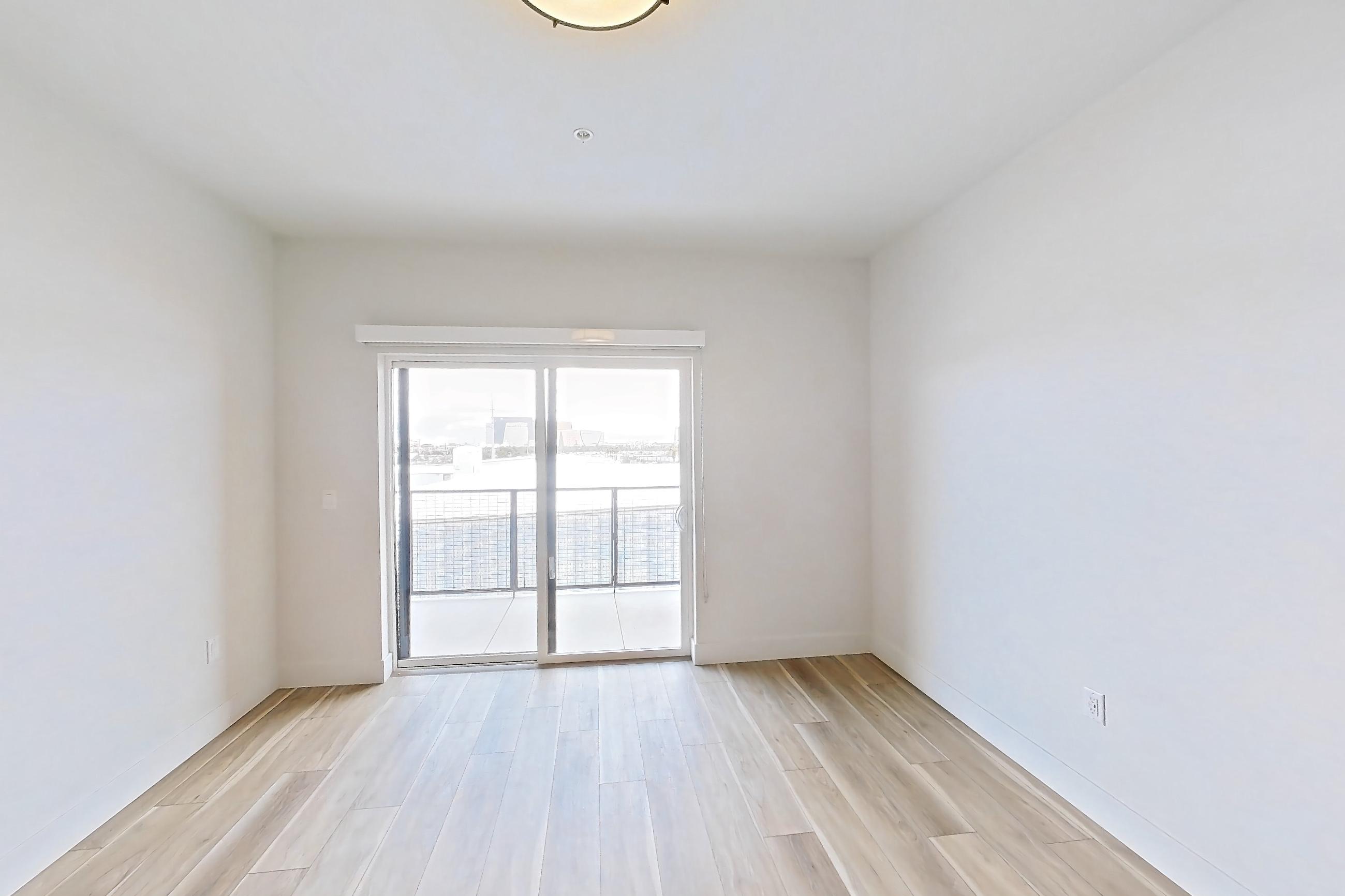 Living room with light wood-finish flooring, Apartment 448 at The Myles