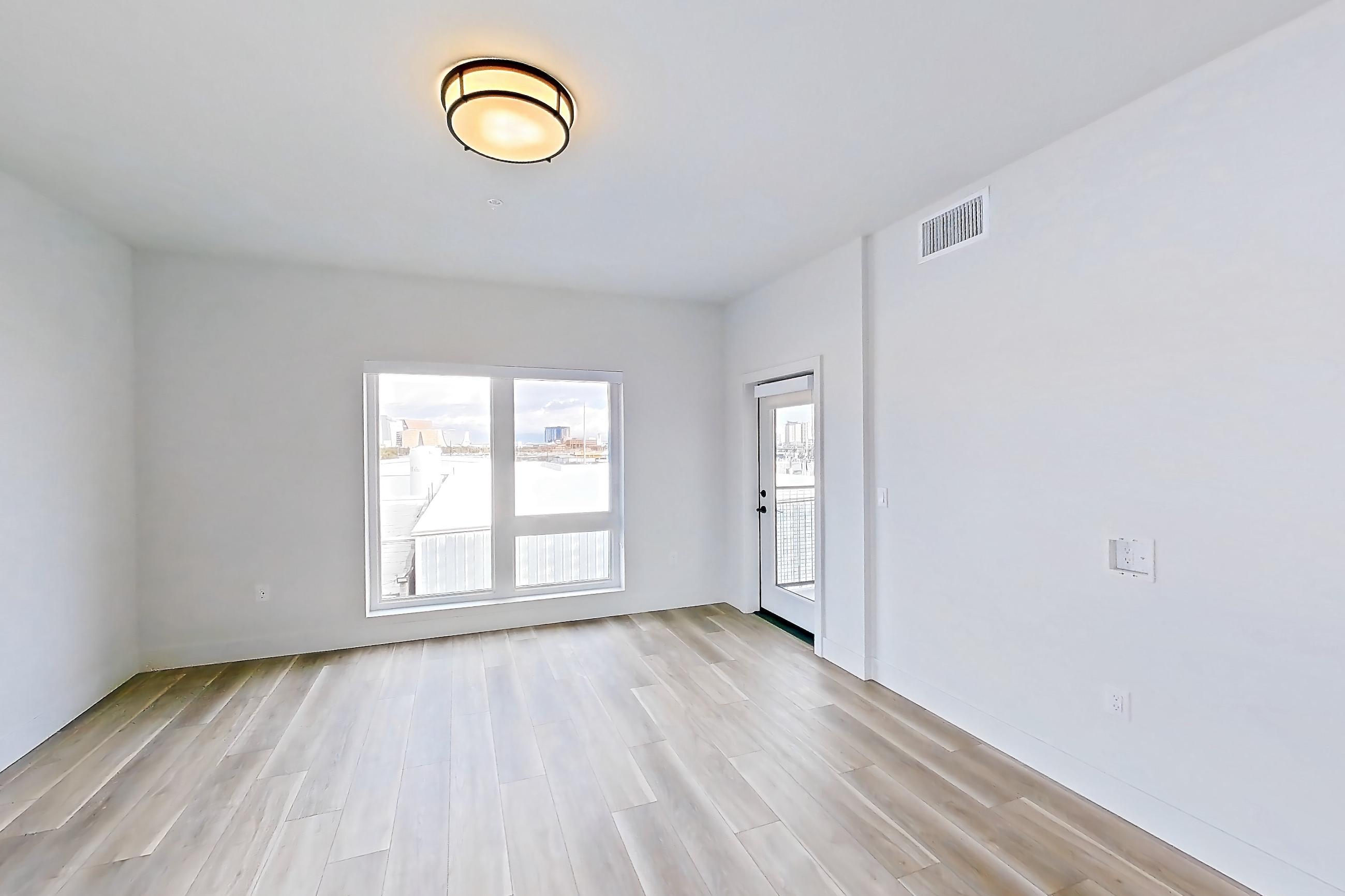 Living room with light wood-finish flooring, Apartment 449 at The Myles