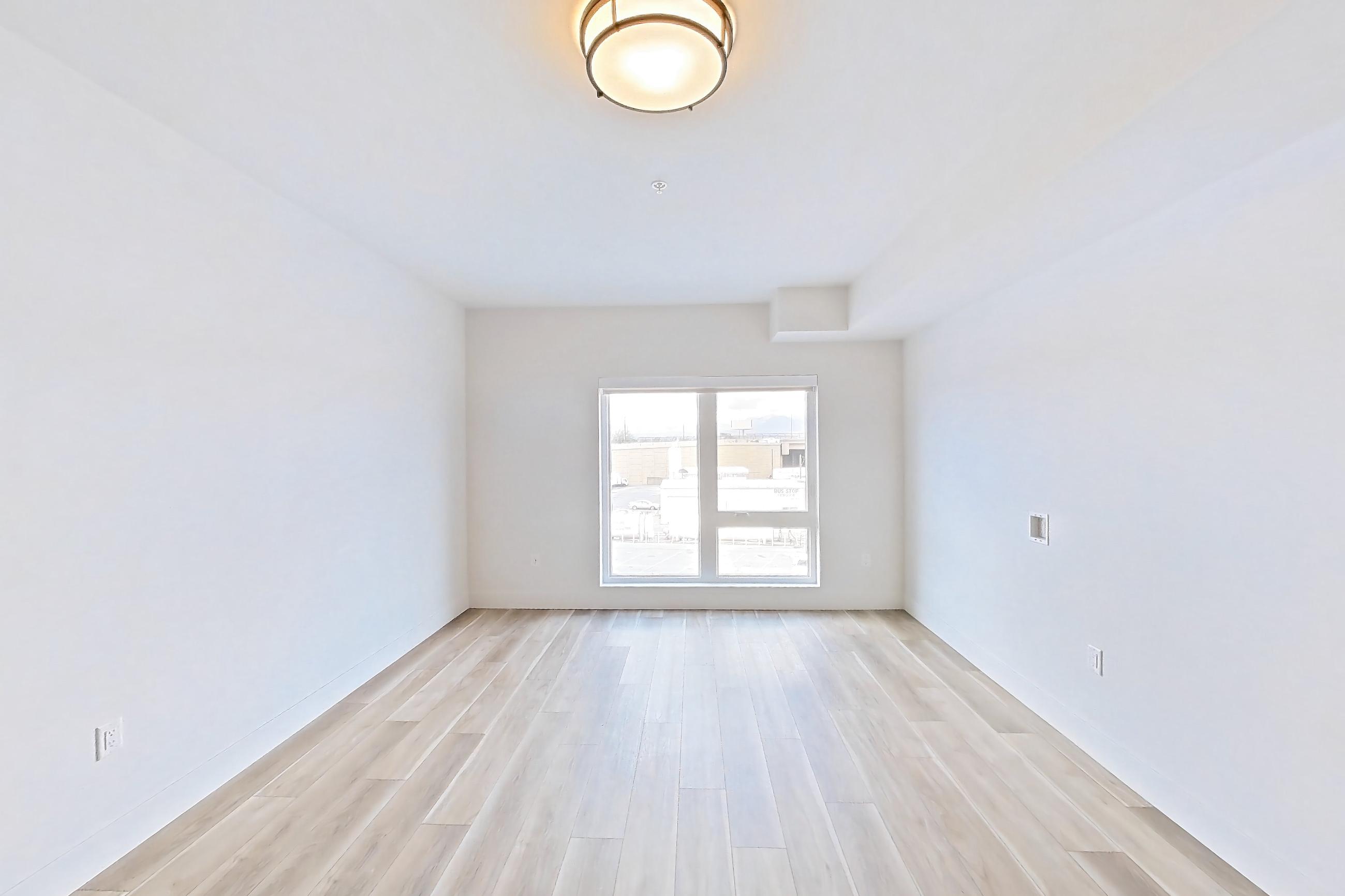 Living room with light wood-finish flooring, Apartment 450 at The Myles