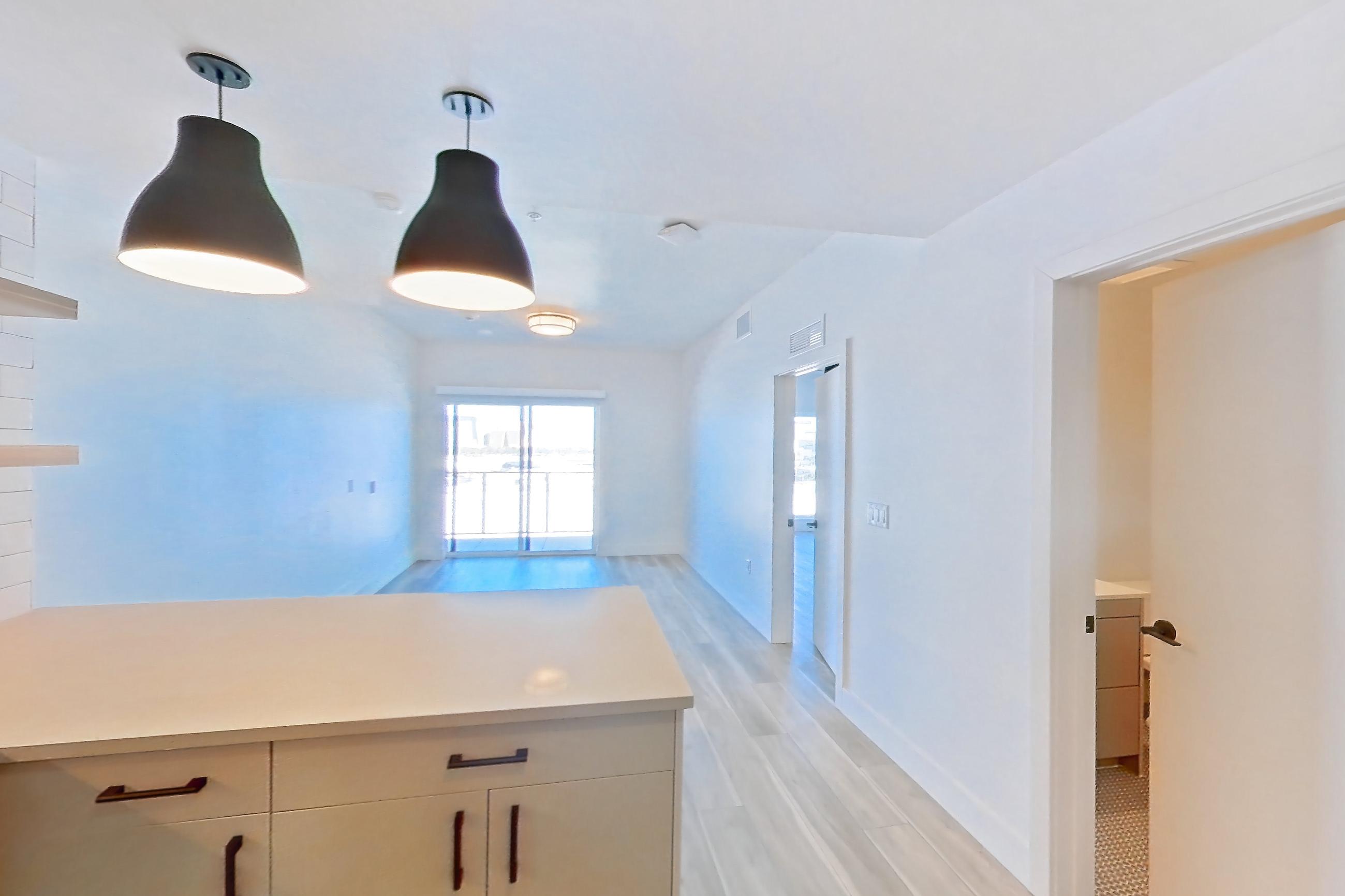 Kitchen with dishwasher, gas range, light countertops, light wood-finish flooring, microwave, oven/range, refrigerator, and stainless steel appliances, Apartment 509 at The Myles