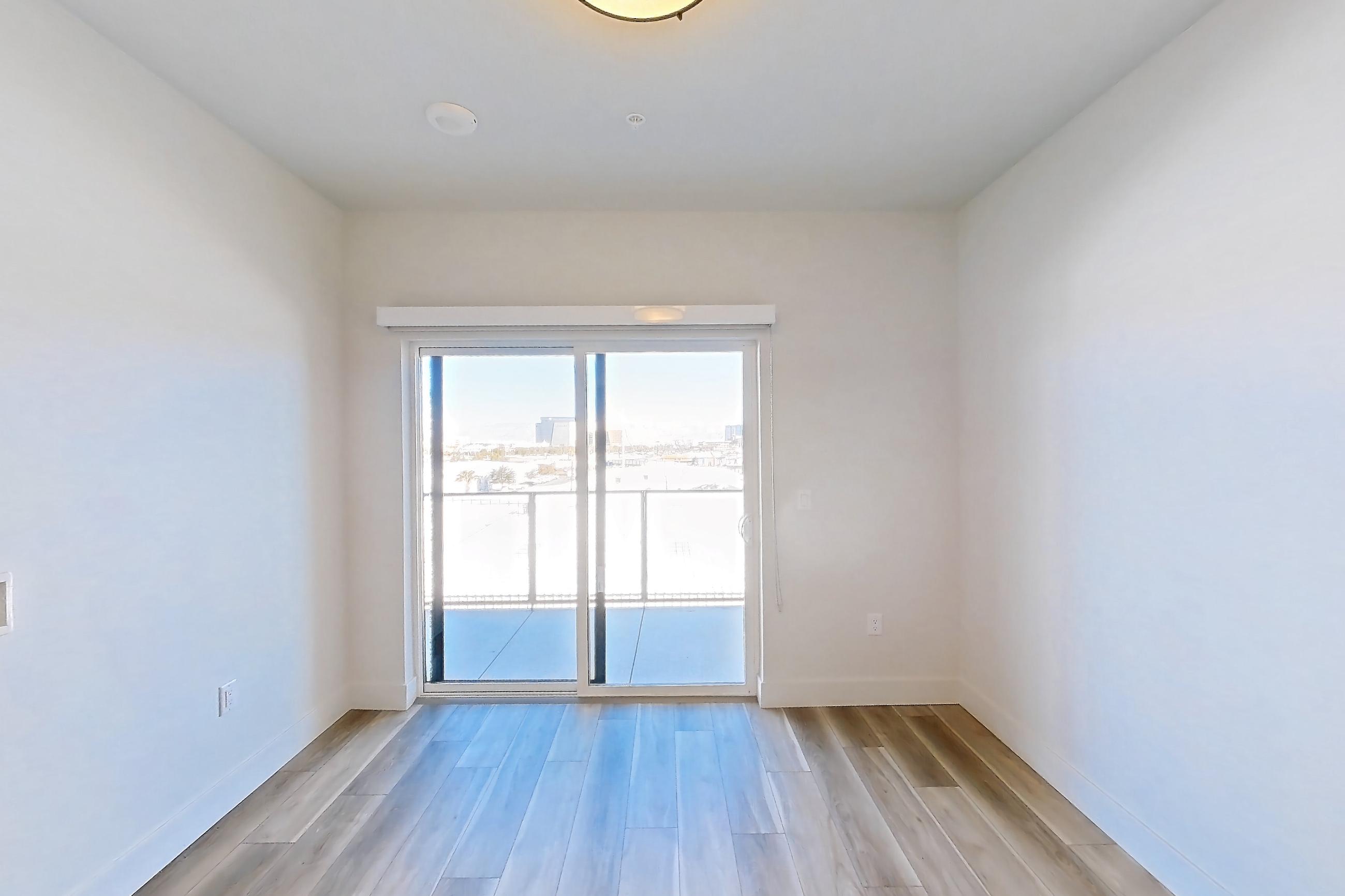 Living room with light wood-finish flooring, Apartment 509 at The Myles