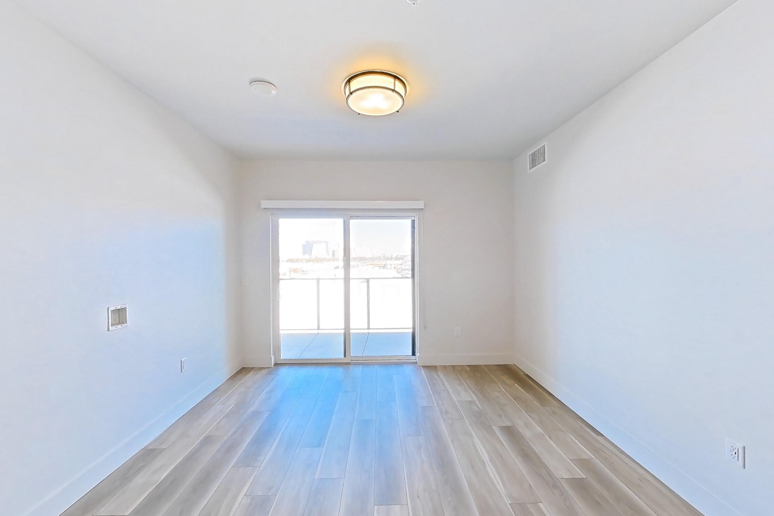 Living room with light wood-finish flooring, Apartment 512 at The Myles