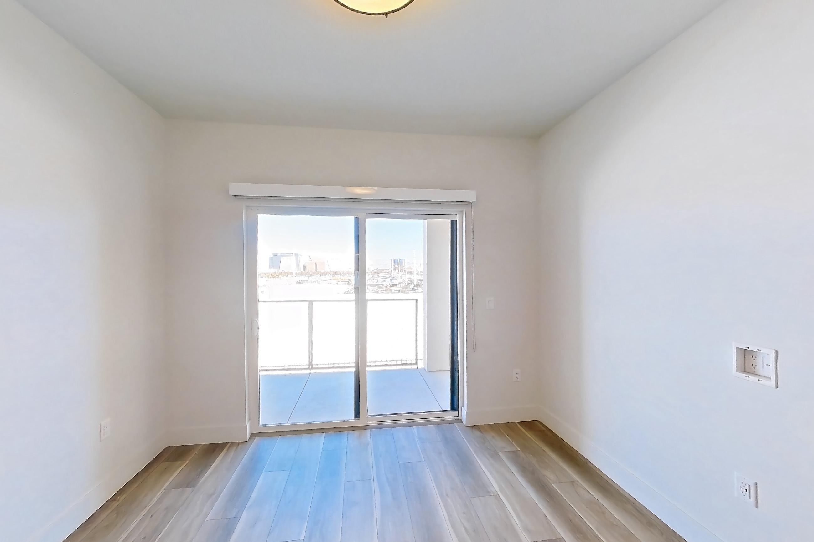 Living room with light wood-finish flooring, Apartment 516 at The Myles
