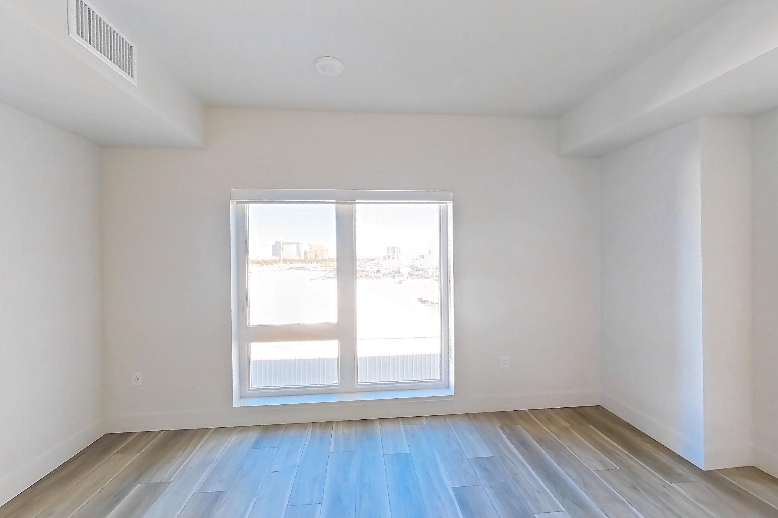Living space with dishwasher, gas range, light countertops, light wood-finish flooring, oven/range, refrigerator, and stainless steel appliances, Apartment 520 at The Myles