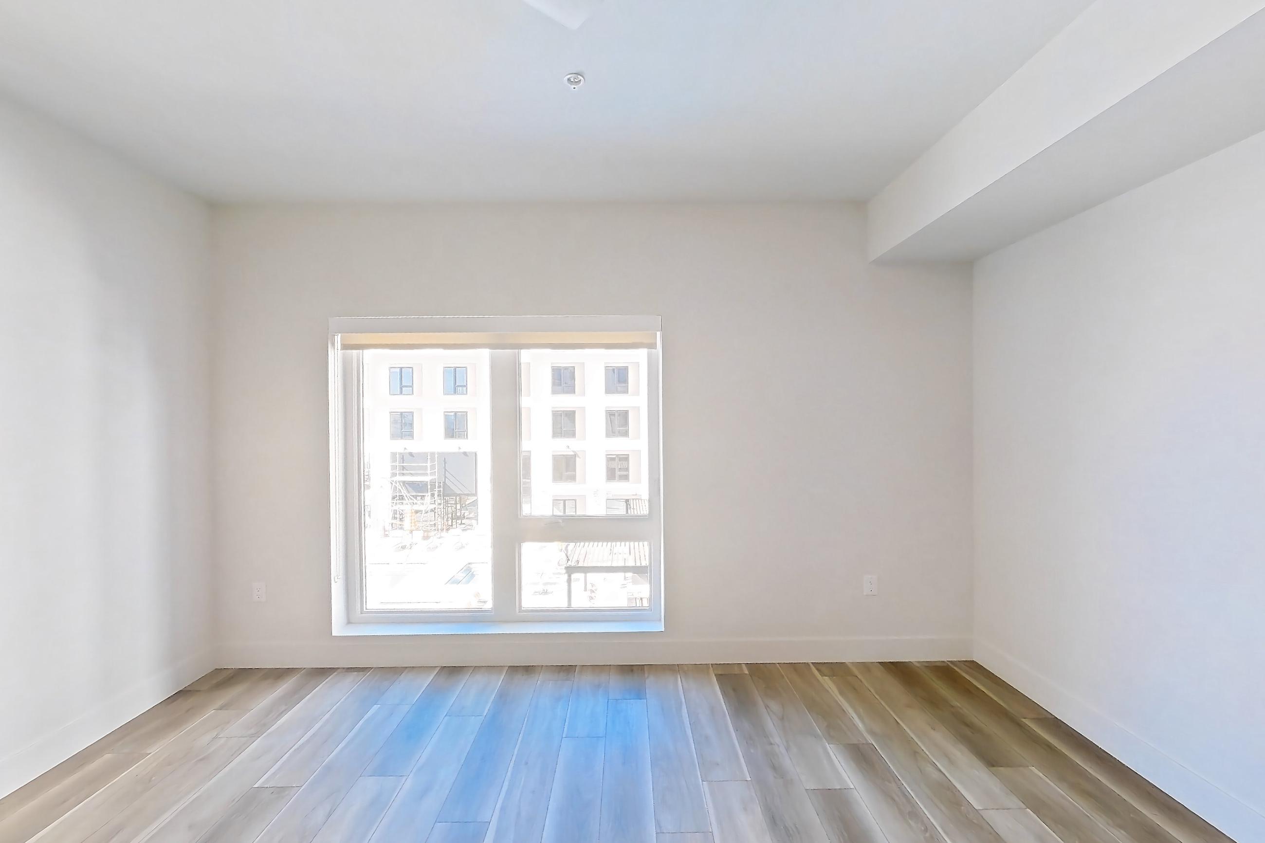 Living room with light wood-finish flooring, Apartment 529 at The Myles