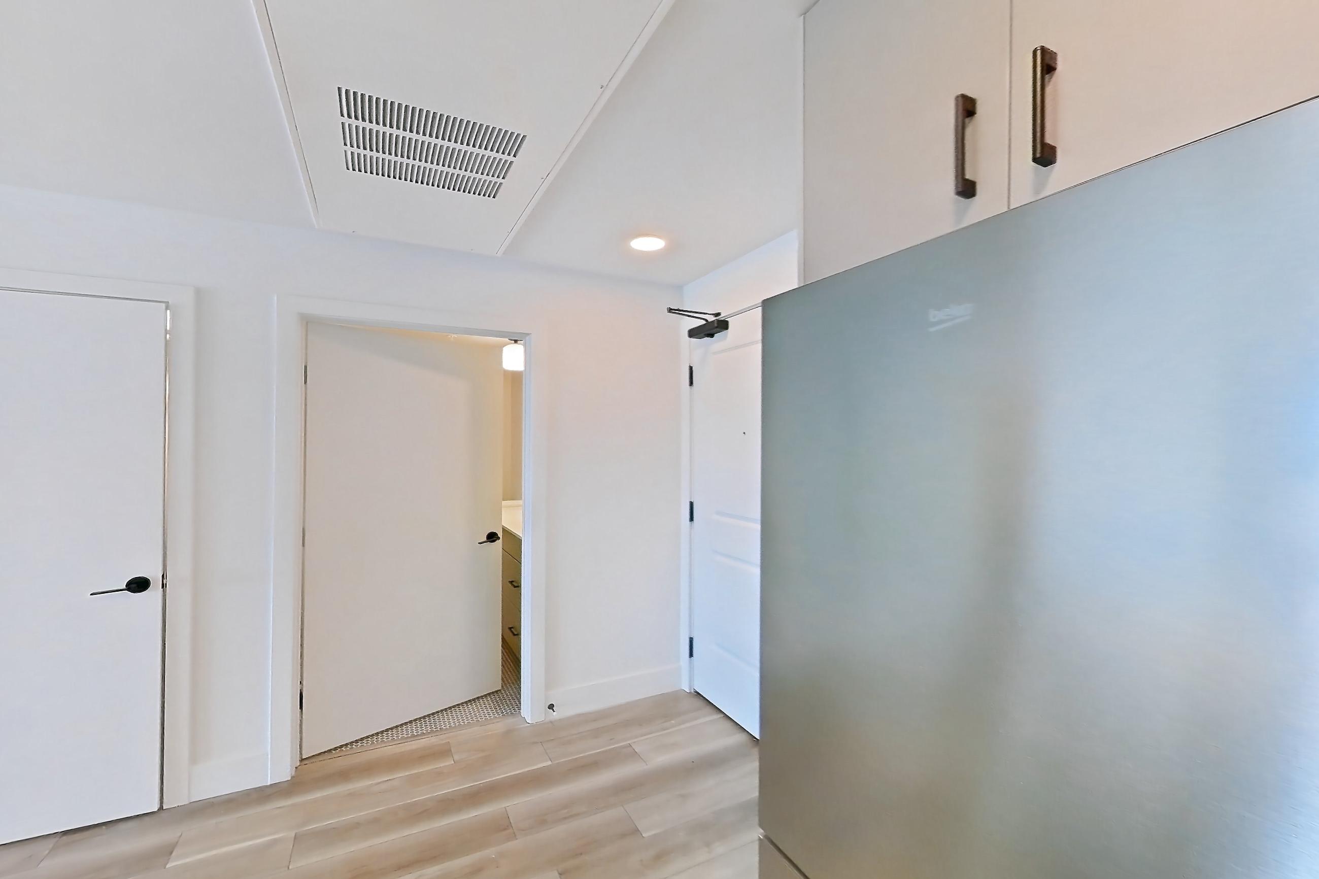Kitchen with dishwasher, gas range, light countertops, light wood-finish flooring, microwave, oven/range, and stainless steel appliances, Apartment 530 at The Myles