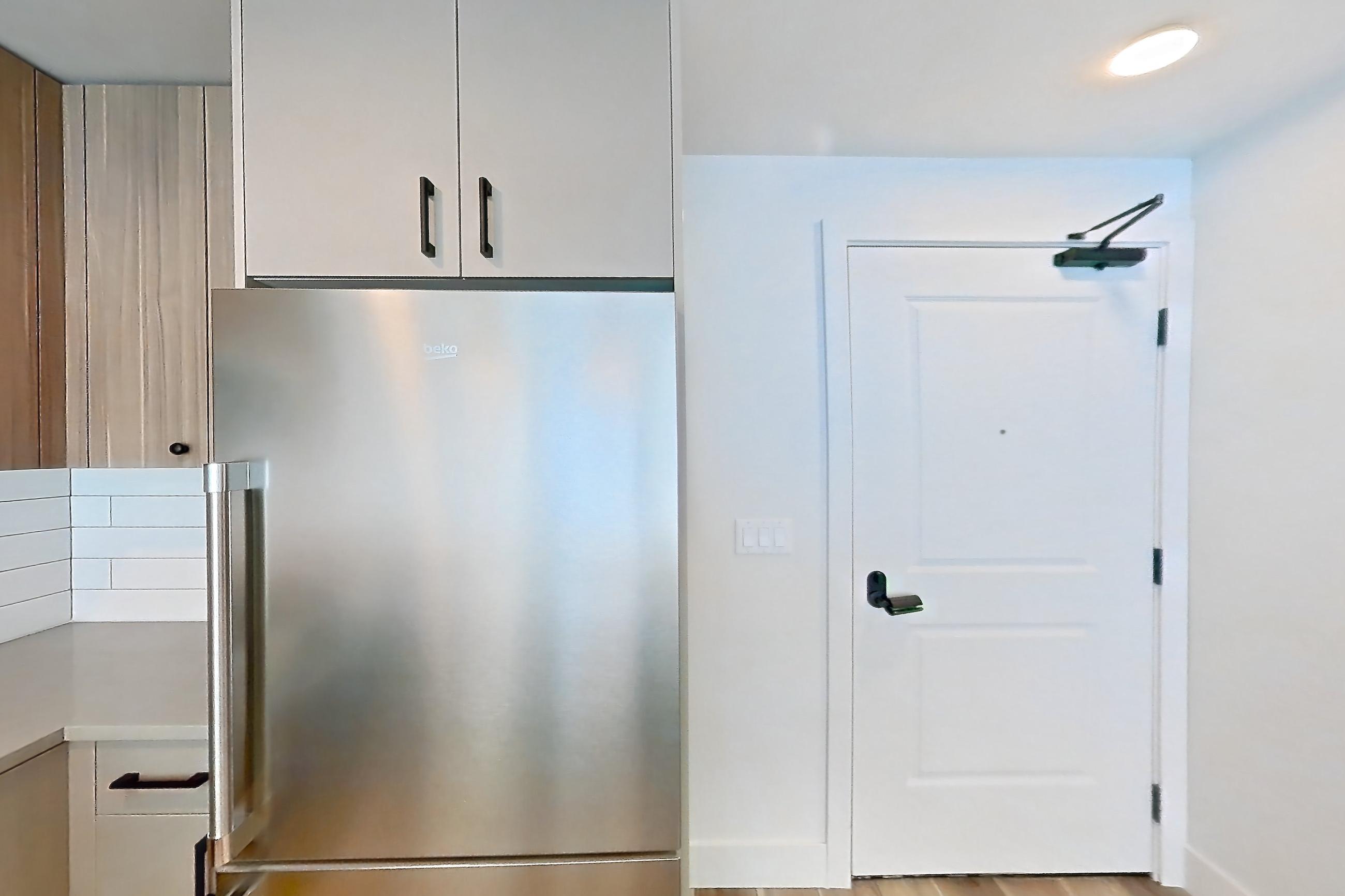 Kitchen with dishwasher, gas range, light countertops, light wood-finish flooring, microwave, oven/range, refrigerator, and stainless steel appliances, Apartment 552 at The Myles