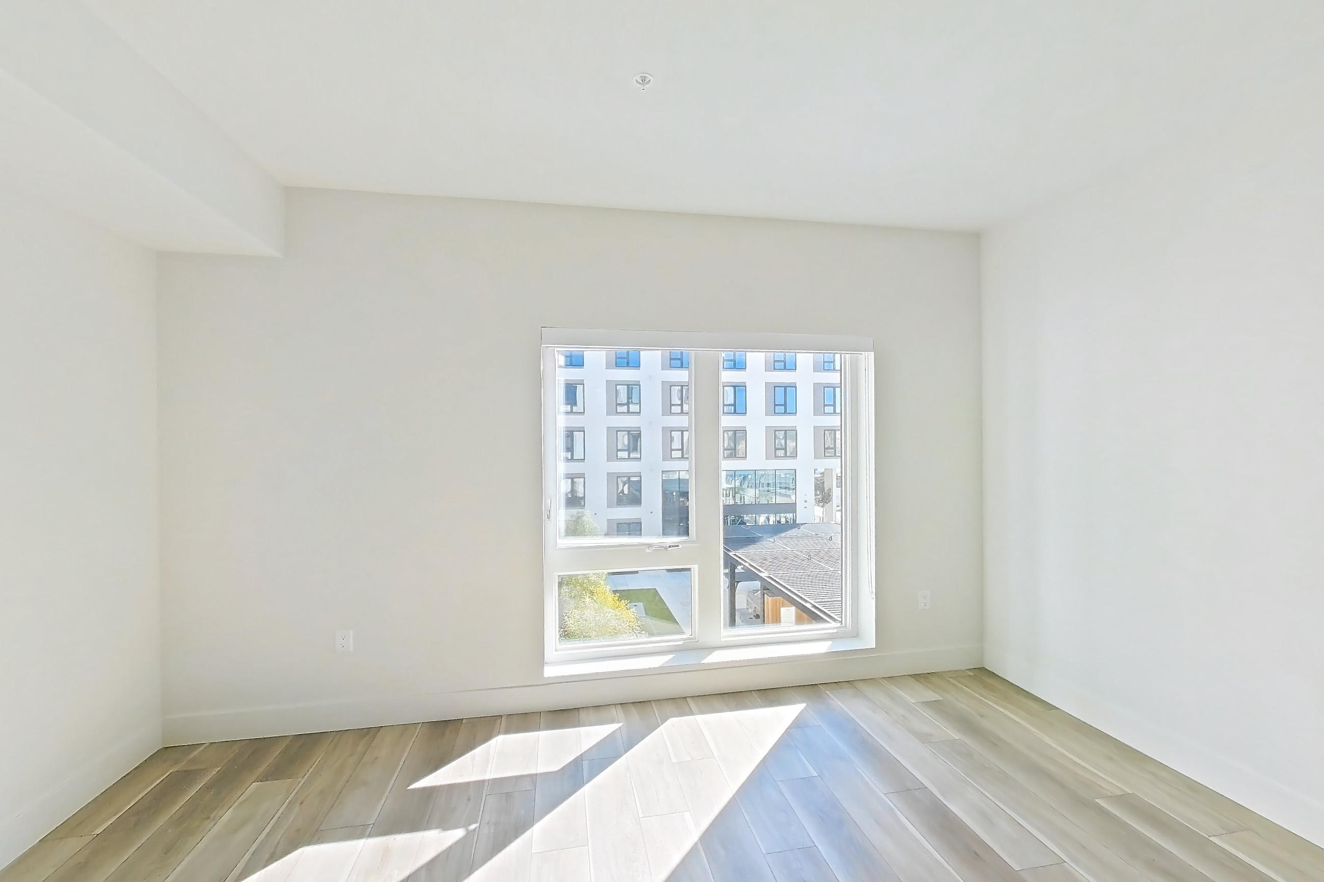 Living room with light wood-finish flooring, refrigerator, stainless steel appliances, and wood-look tile flooring, Apartment 554 at The Myles