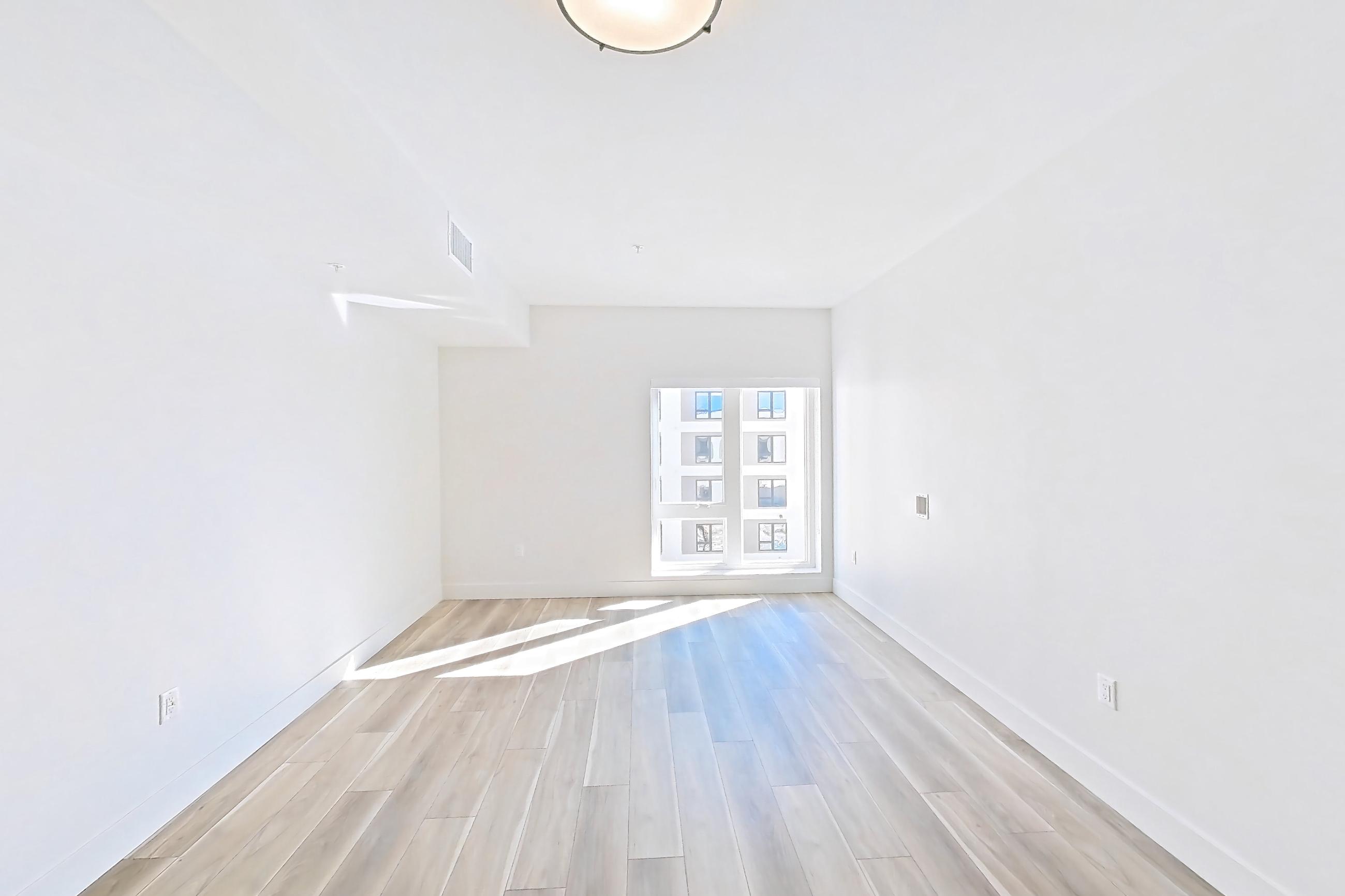 Living room with light wood-finish flooring, Apartment 601 at The Myles