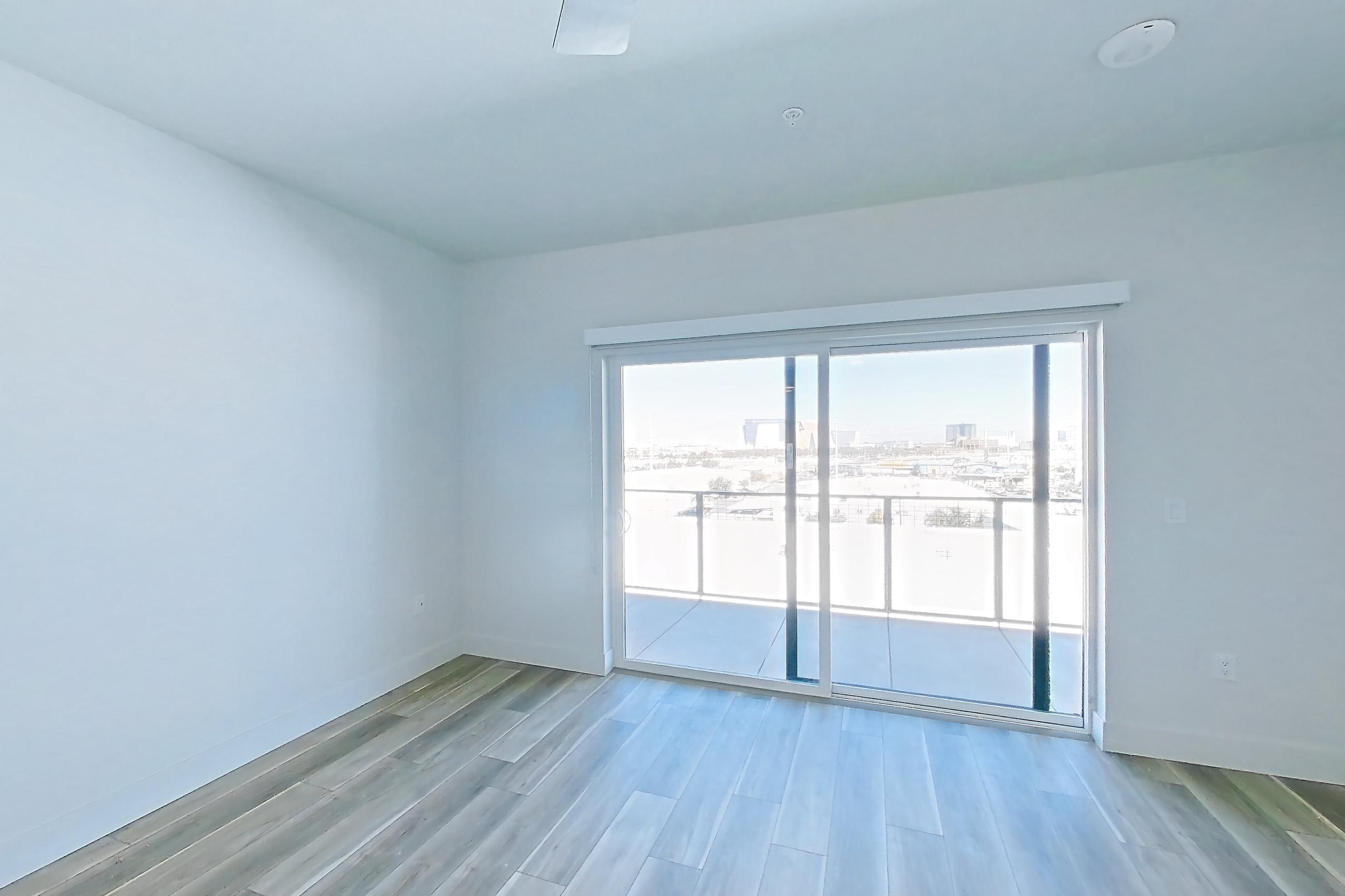 Living space with dishwasher, gas range, light stone countertops, light wood-finish flooring, oven/range, and stainless steel appliances, Apartment 608 at The Myles