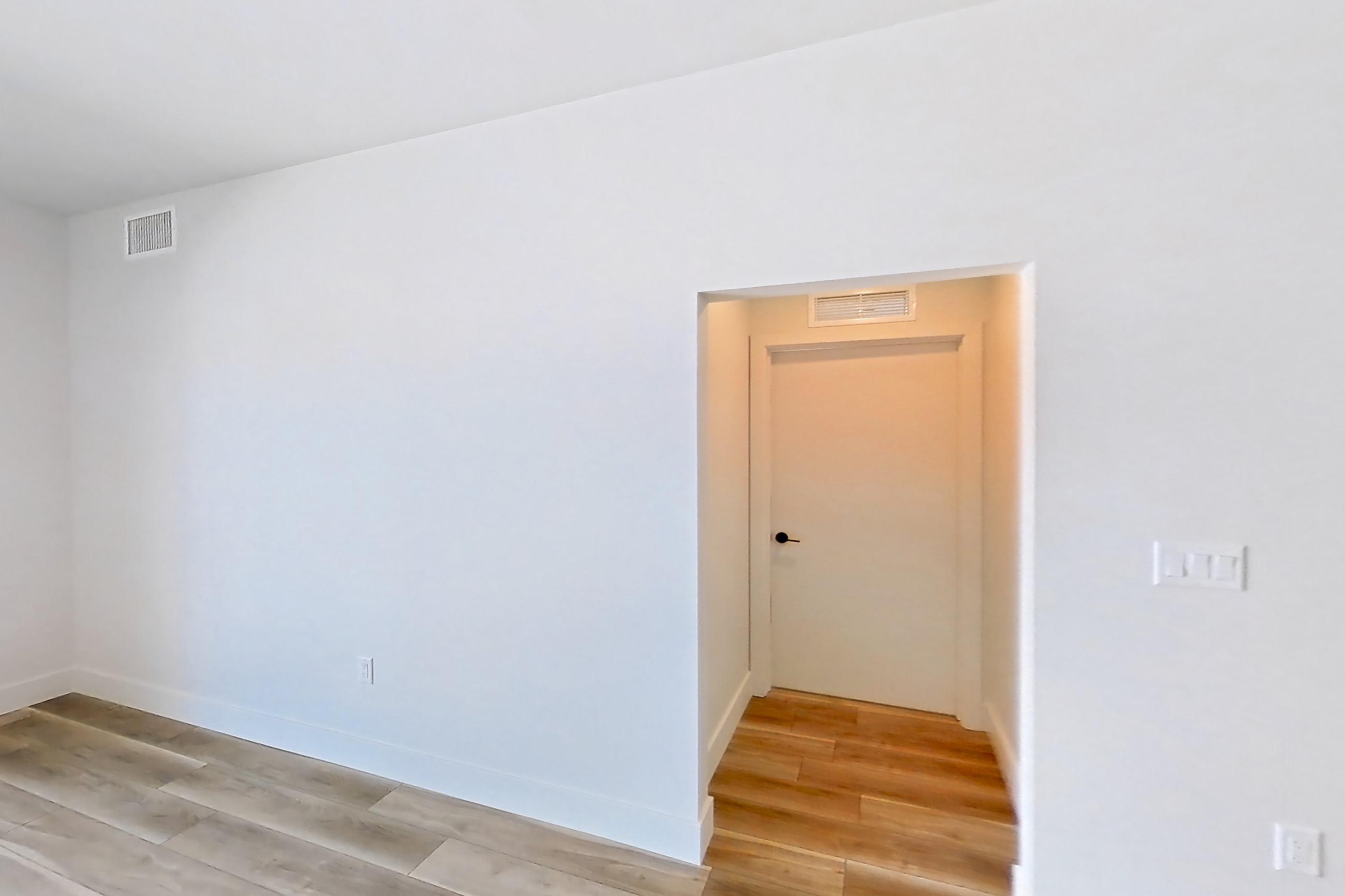 Living room with light wood-finish flooring, Apartment 612 at The Myles