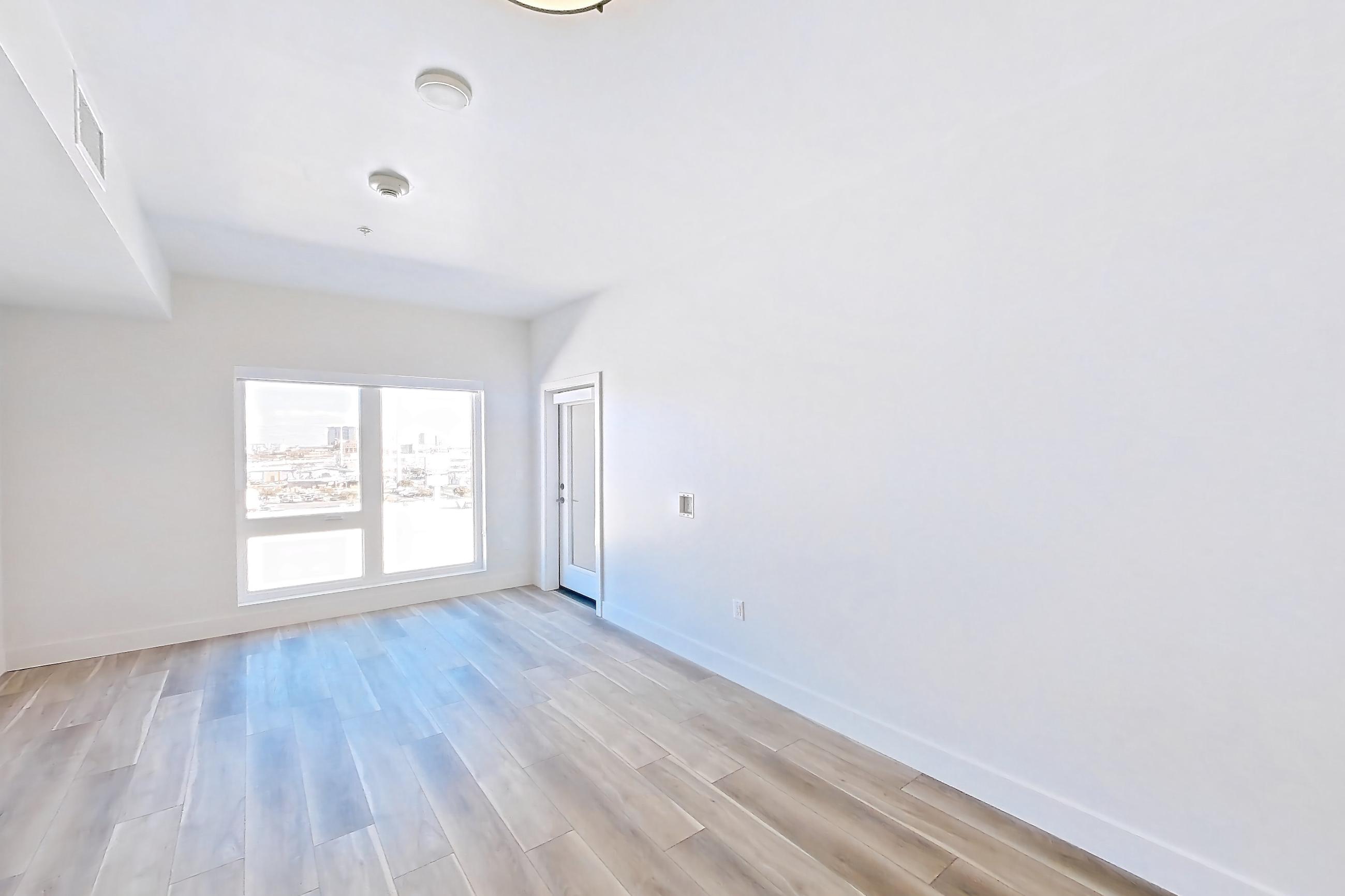 Living room with light wood-finish flooring, Apartment 614 at The Myles