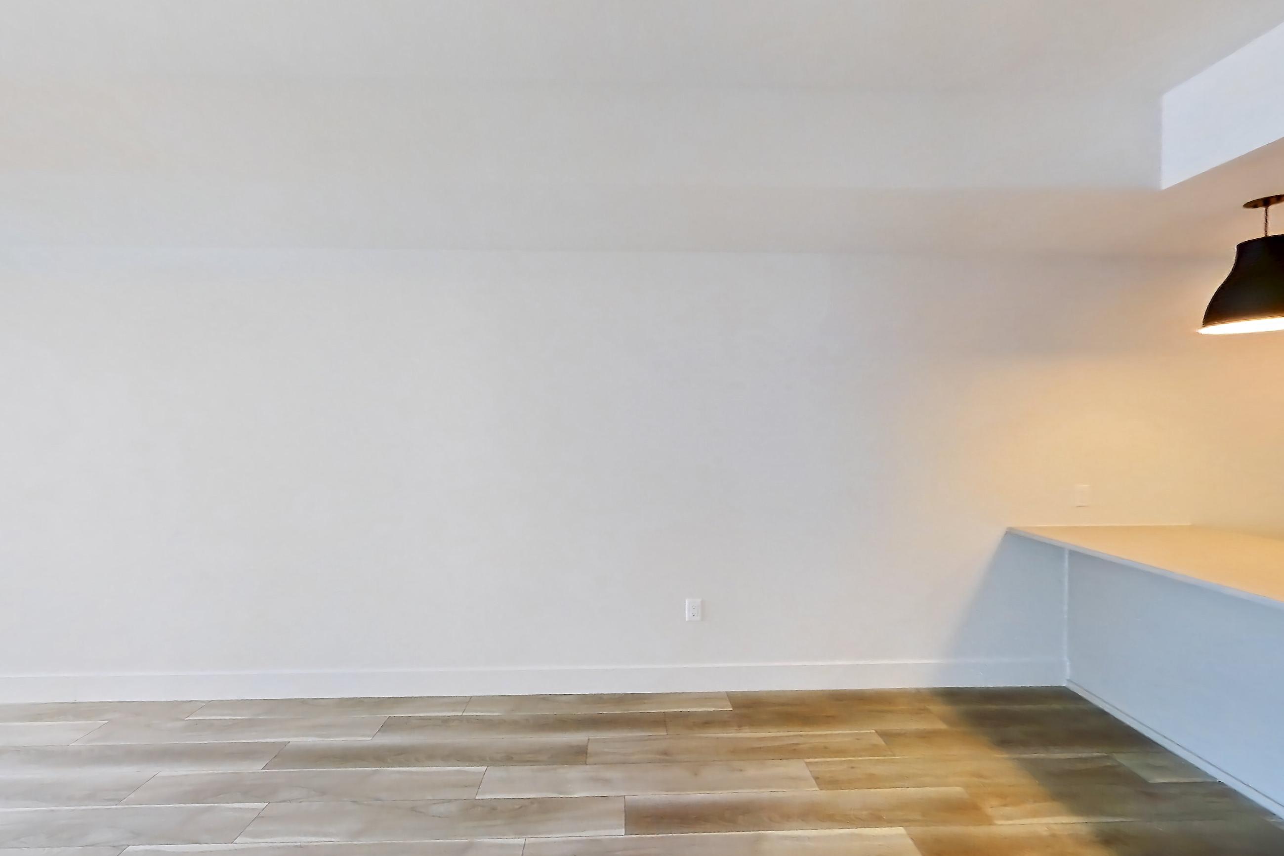 Living room with light countertops and light wood-finish flooring, Apartment 621 at The Myles