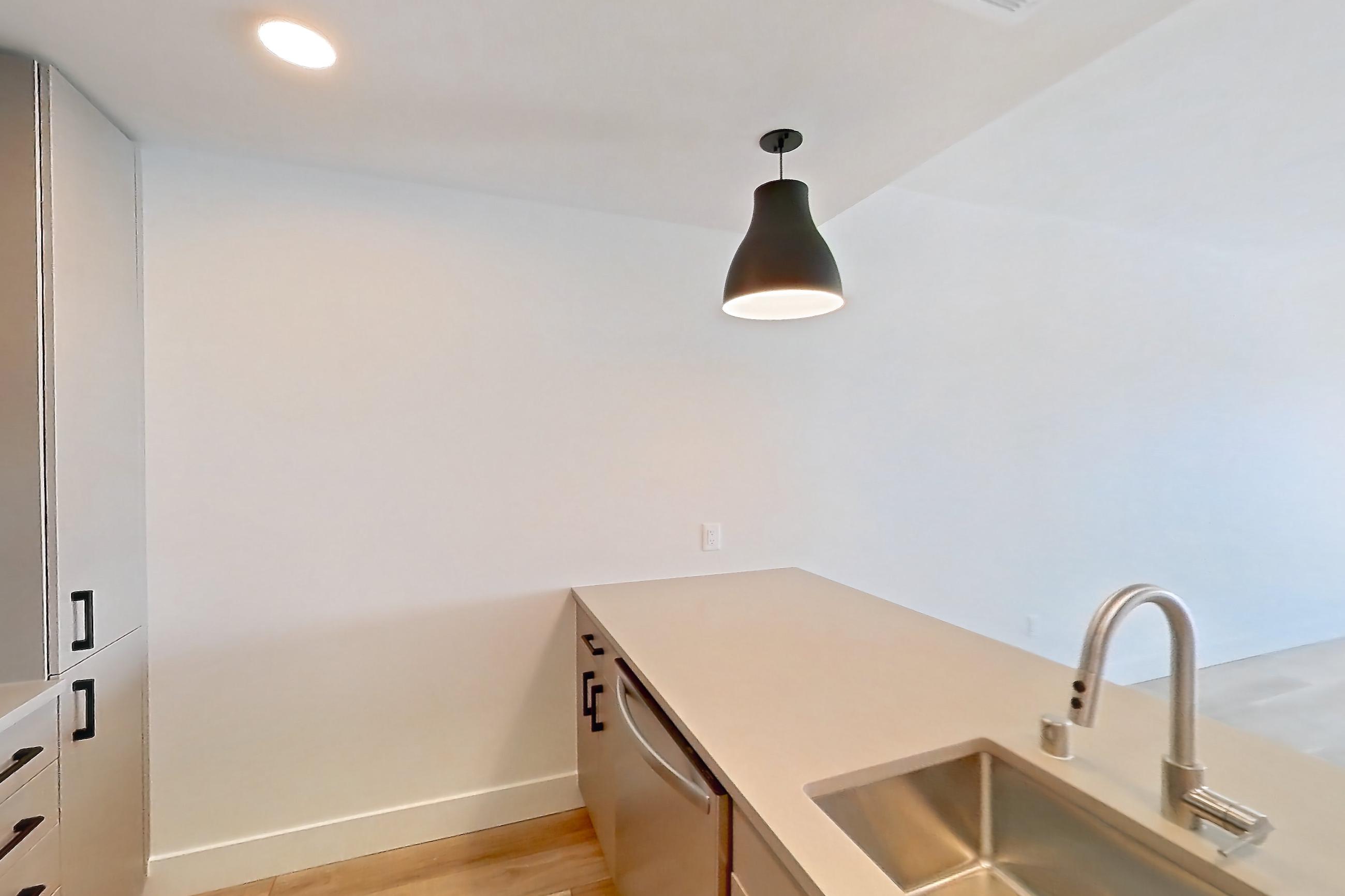 Kitchen with dishwasher, gas range, light countertops, light wood-finish flooring, microwave, oven/range, and stainless steel appliances, Apartment 630 at The Myles