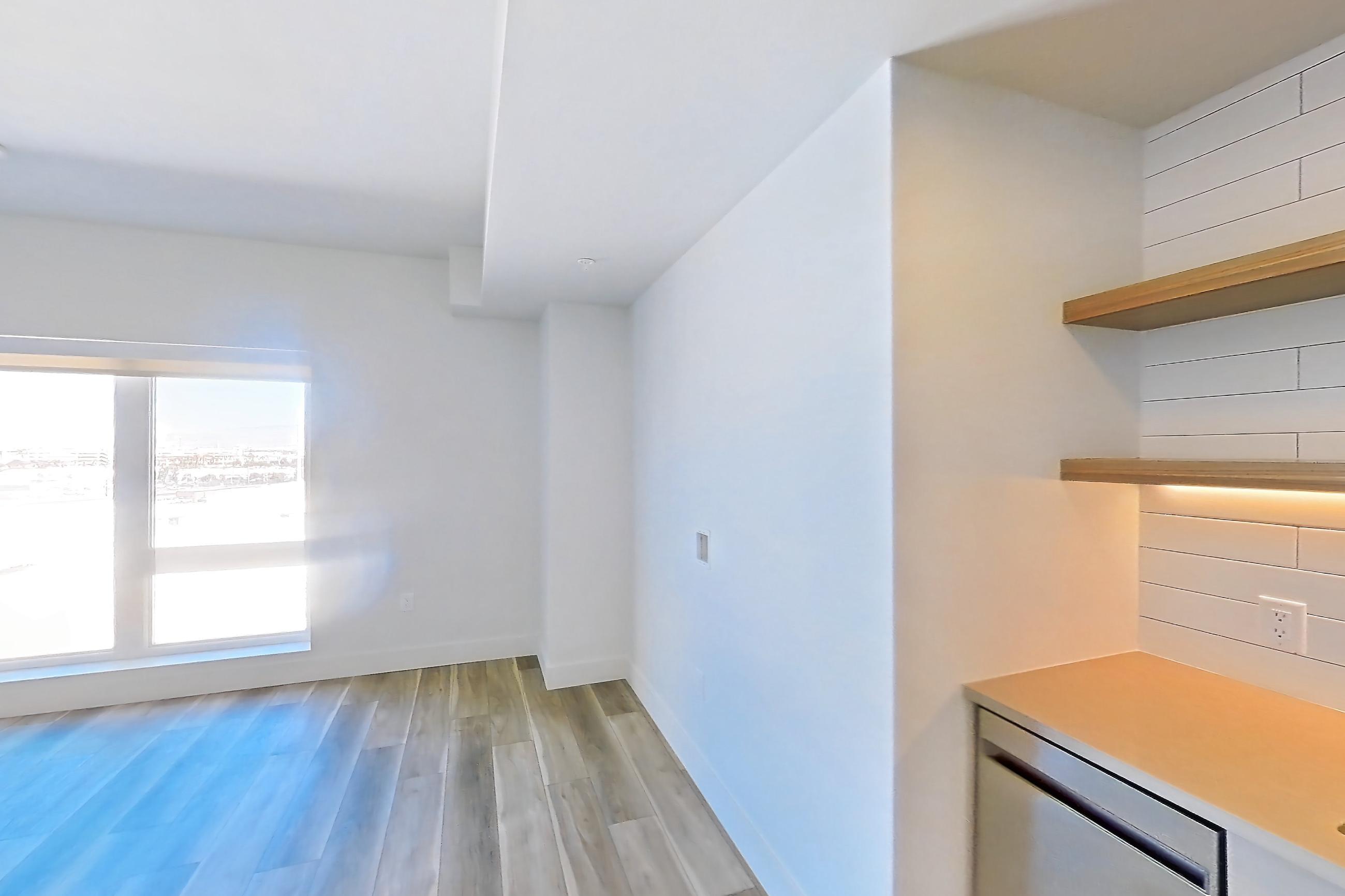 Kitchen with dishwasher, gas range, light countertops, light wood-finish flooring, oven/range, refrigerator, and stainless steel appliances, Apartment 643 at The Myles