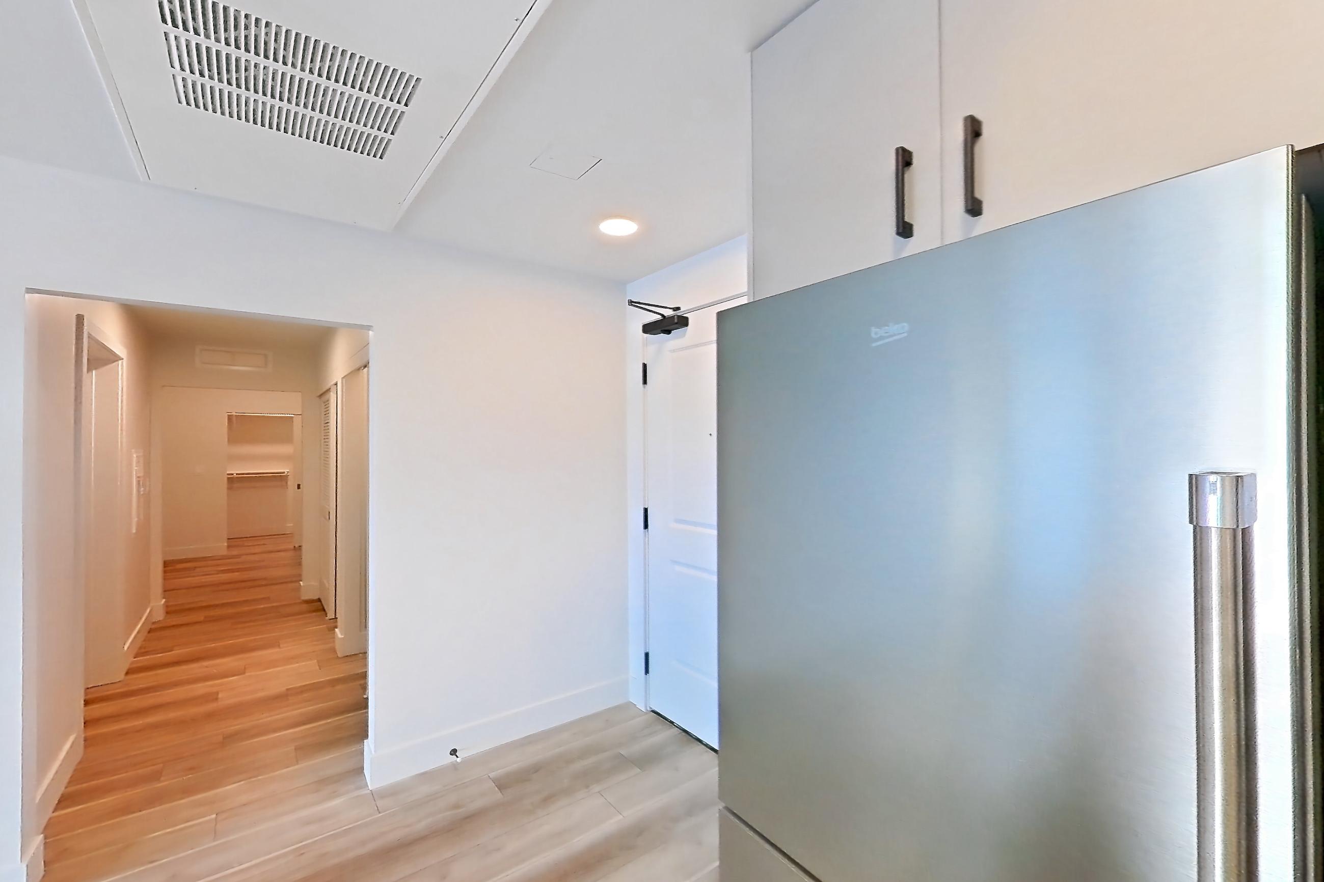Kitchen with gas range, light countertops, light wood-finish flooring, oven/range, refrigerator, and stainless steel appliances, Apartment 646 at The Myles