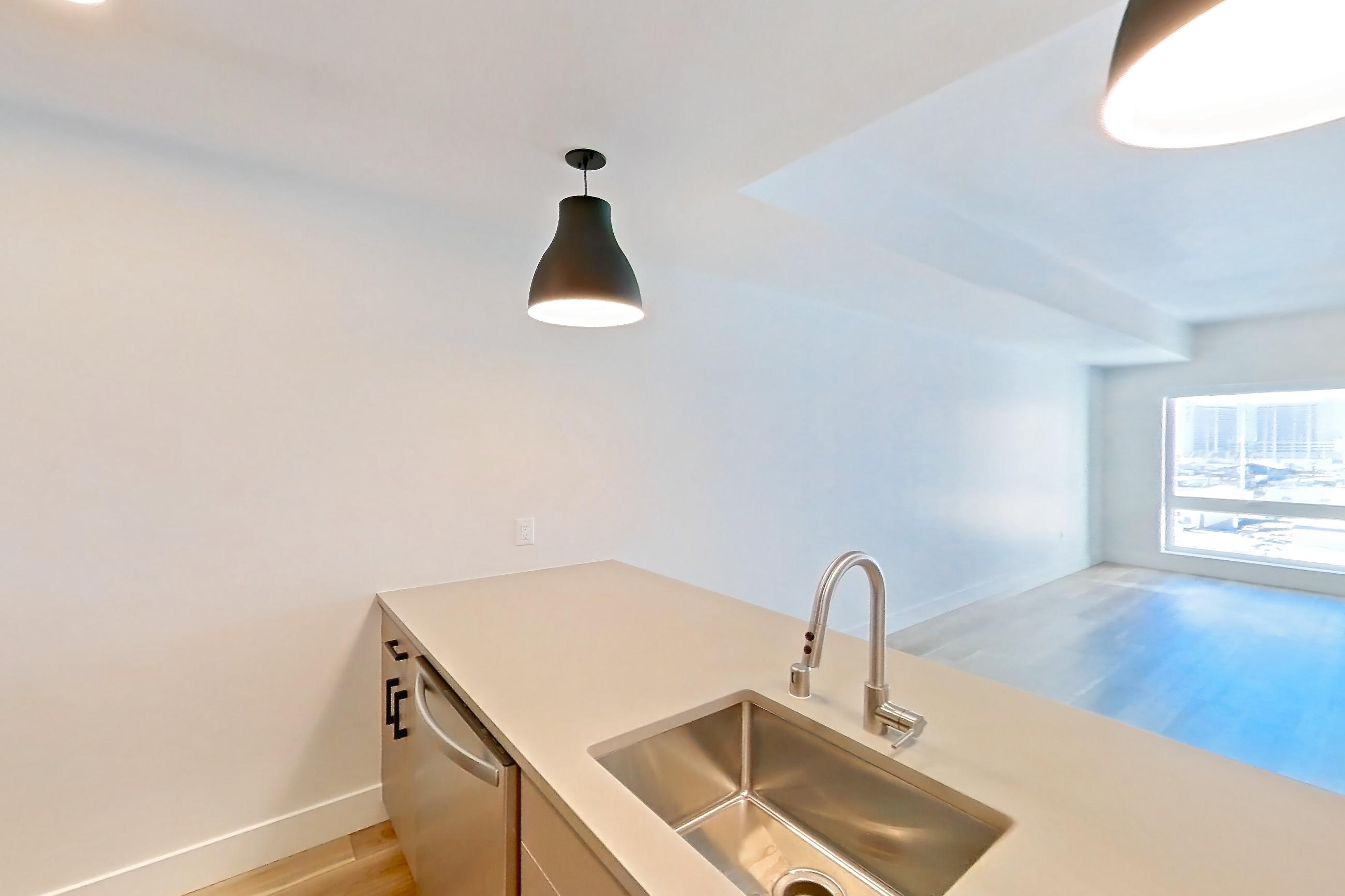 Kitchen with gas range, light countertops, light wood-finish flooring, oven/range, refrigerator, and stainless steel appliances, Apartment 646 at The Myles