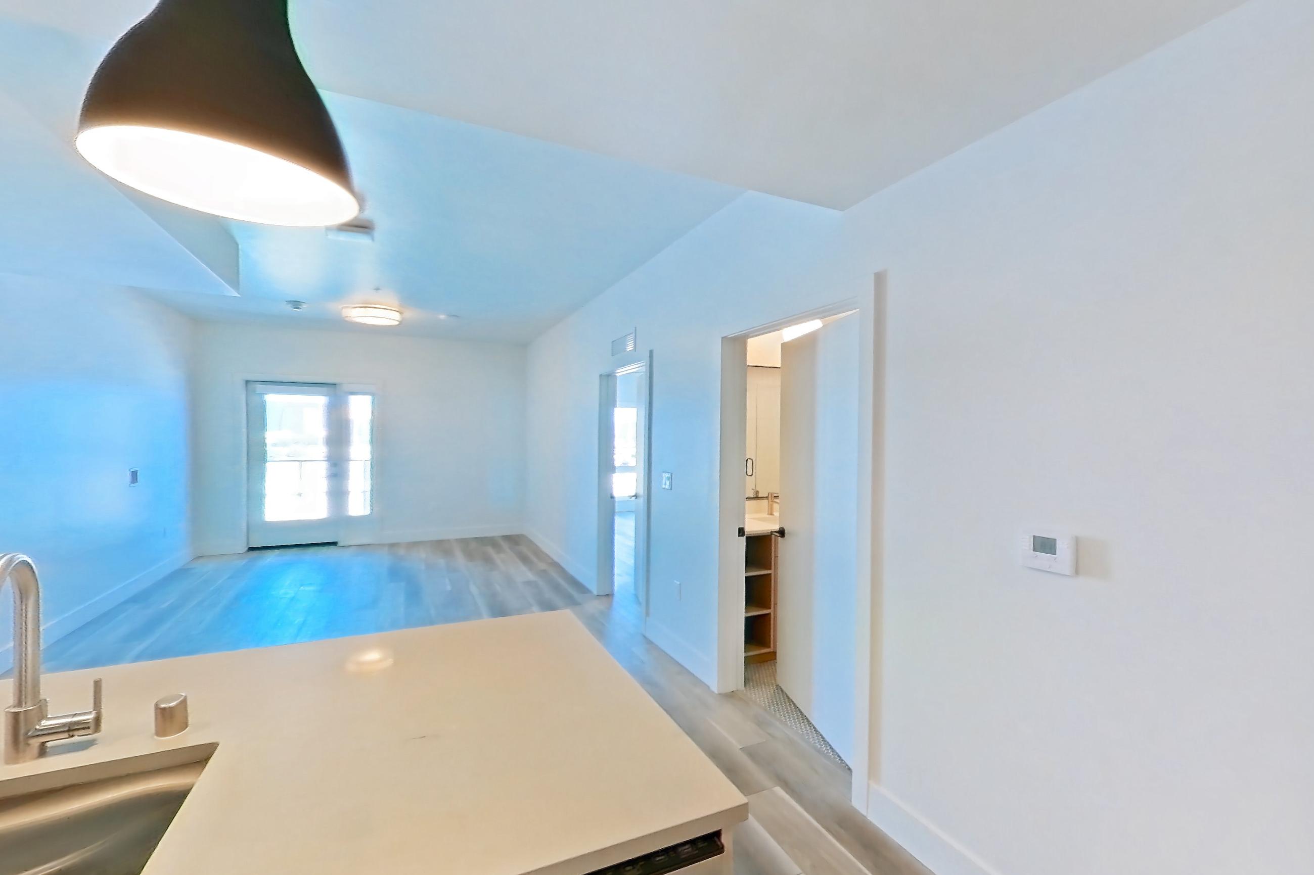 Kitchen with dishwasher, gas range, light countertops, light wood-finish flooring, microwave, oven/range, refrigerator, and stainless steel appliances, Apartment 647 at The Myles