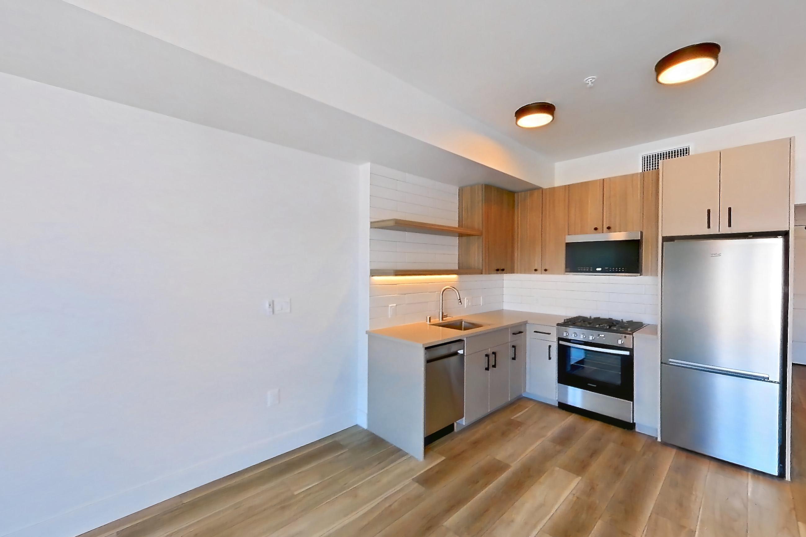 Living space with dishwasher, light wood-finish flooring, and stainless steel appliances, Apartment 653 at The Myles