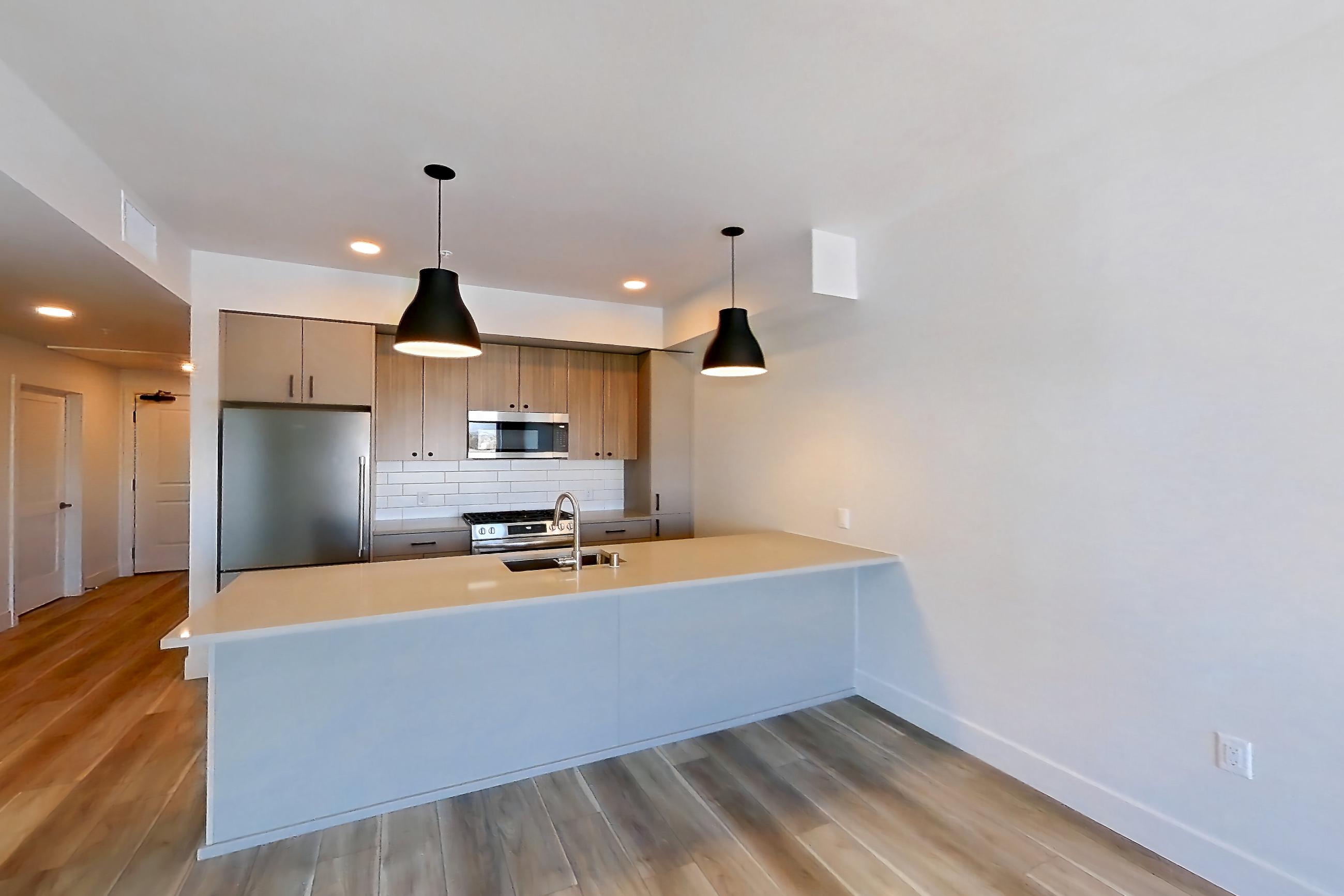 Living room with light wood-finish flooring, Apartment 655 at The Myles